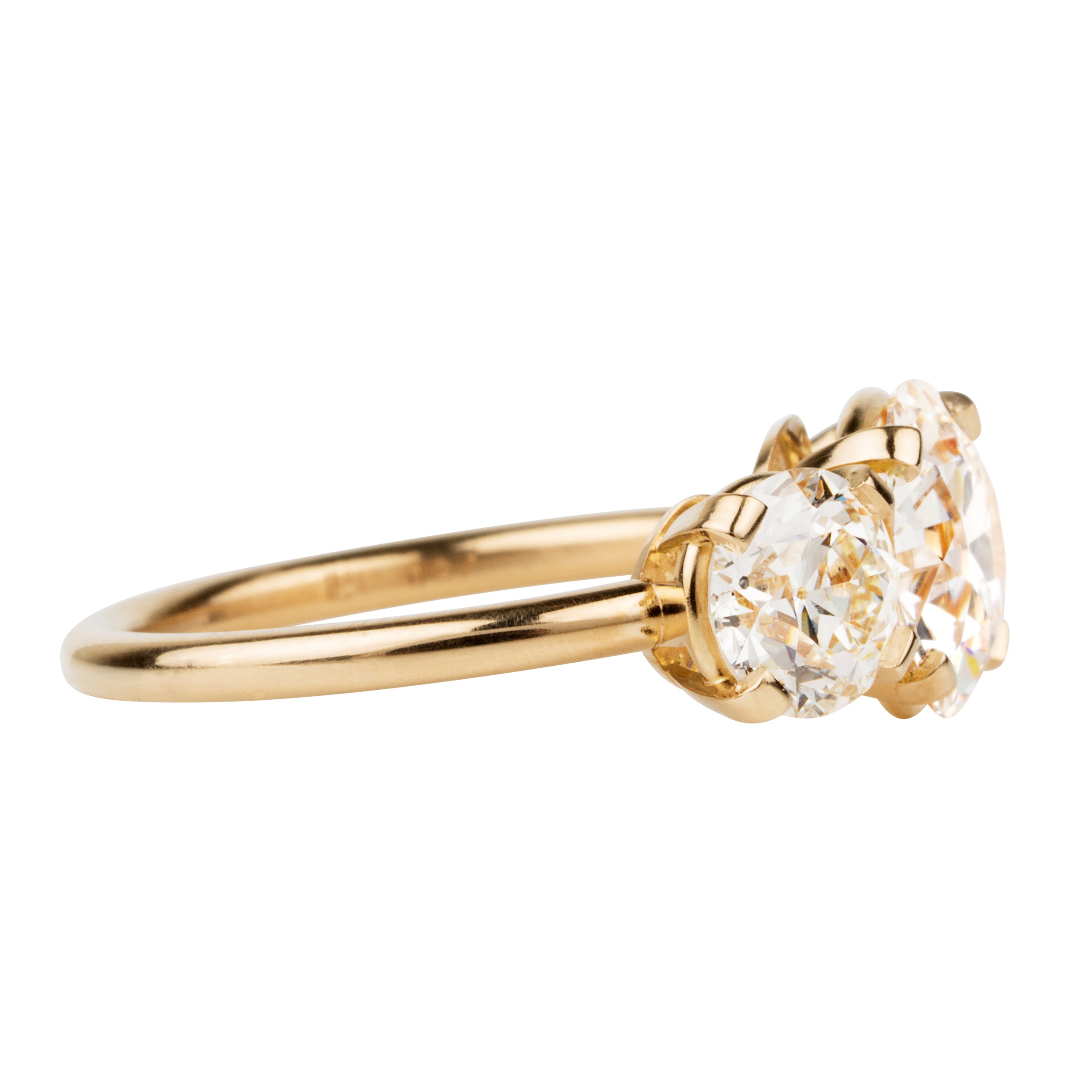 A classic three-stone diamond ring in our 18k old gold featuring a slim band. The center stone is set with four tab prongs. This example features three old European cut diamonds. The center stone in this example is 1.93-carat diamond, GIA-certified H color, and VS1 clarity. Flanked by 2 old European cut diamond side stones, 0.85 carats and 0.76 carats J Color/ VS1 clarity.