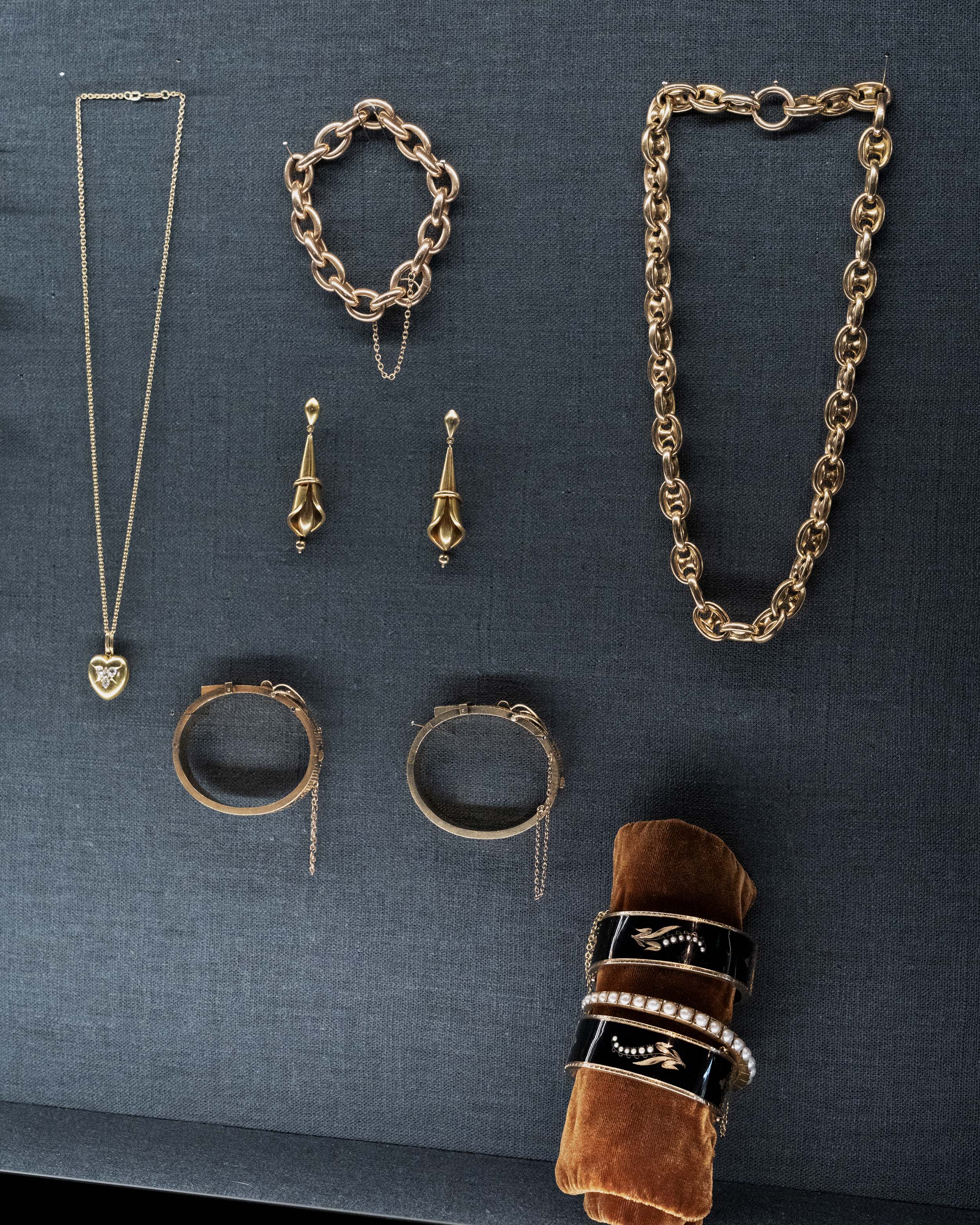 View of a jewelry case with several antique Victorian gold jewelry pieces.