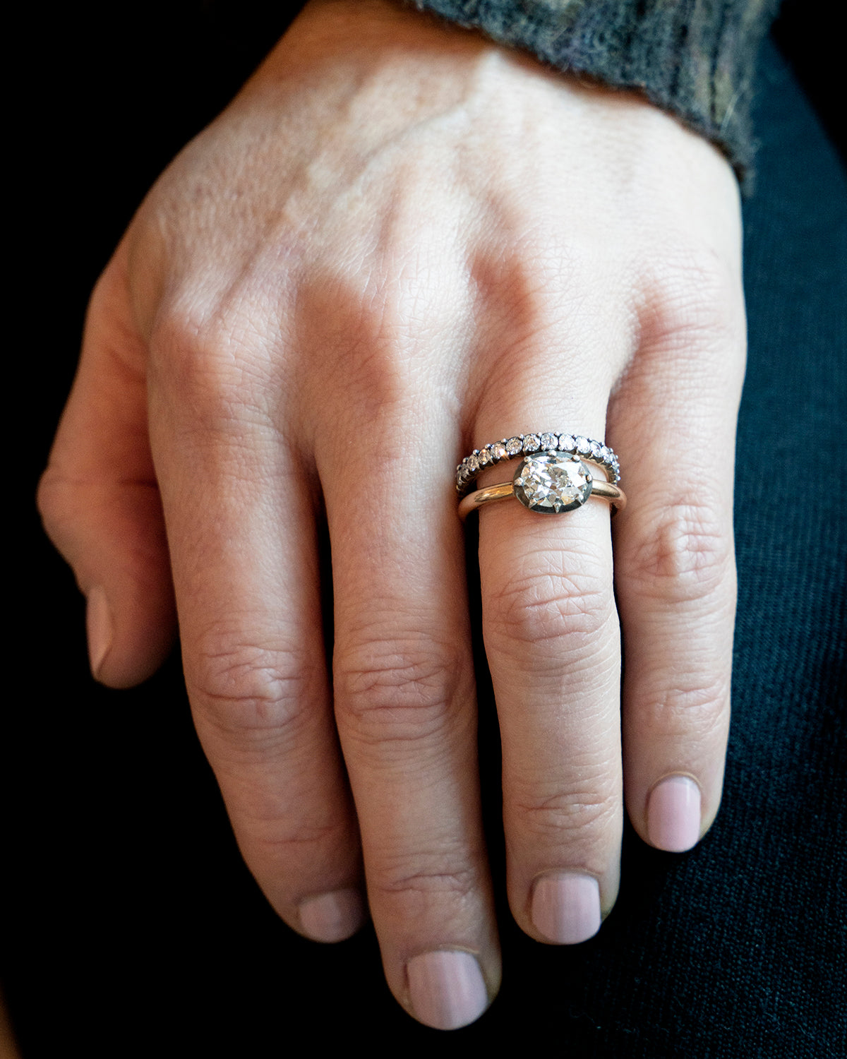 One of our signature designs, in silver-topped 18k gold. This design s inspired by a labor-intensive setting technique common in 18th and 19th-century rings. The silver-on-gold technique is true to the rings that inspired this design and is rarely seen in modern jewelry. This features a GIA certified cushion cut diamond 1.43 carat, I color and VS2 clarity. The ring being modeled on a hand.