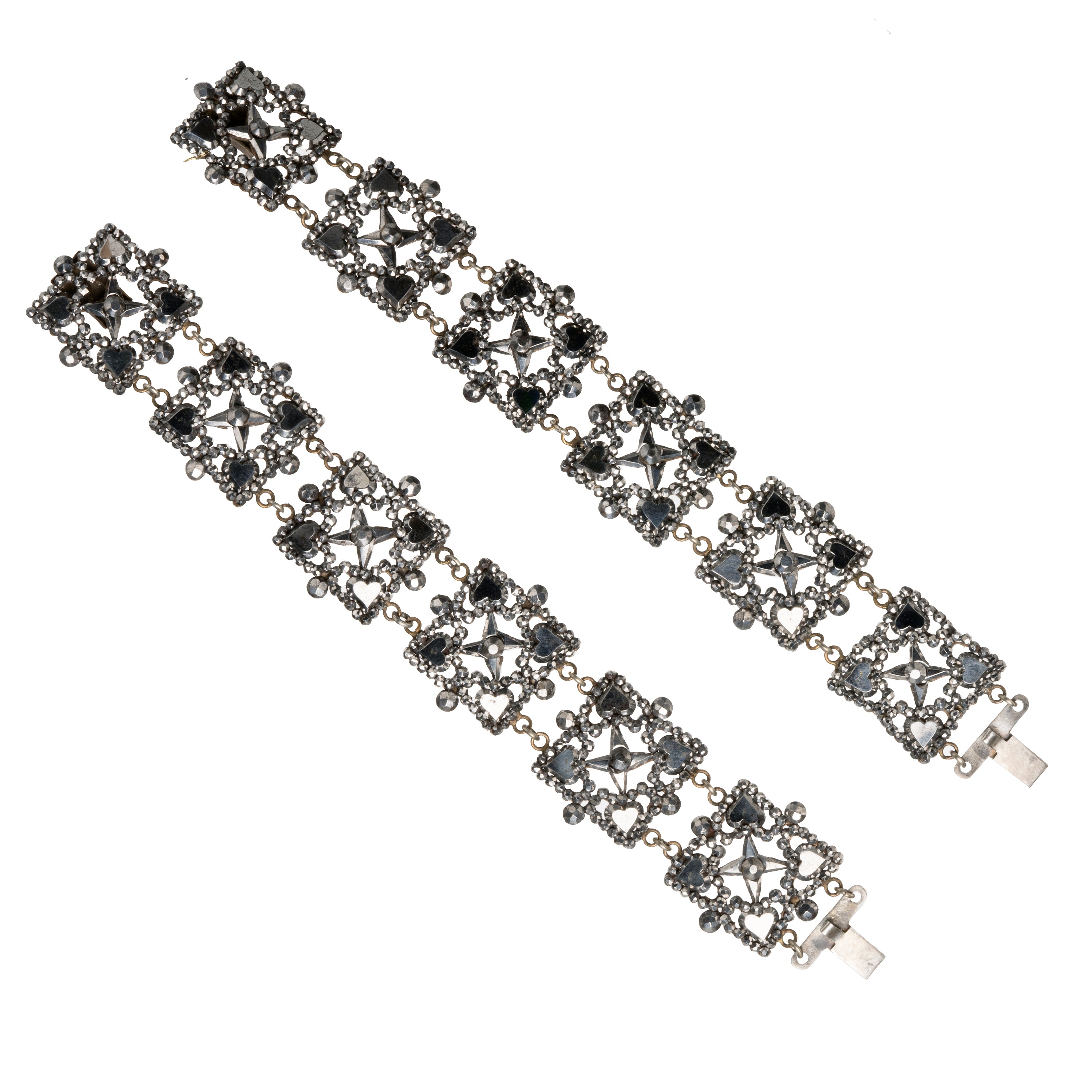 Bright steel panels make up links in these bracelets. A rare set still together after many generations. A subtle heart motif is integrated into the design. English in origin. Circa 1840.