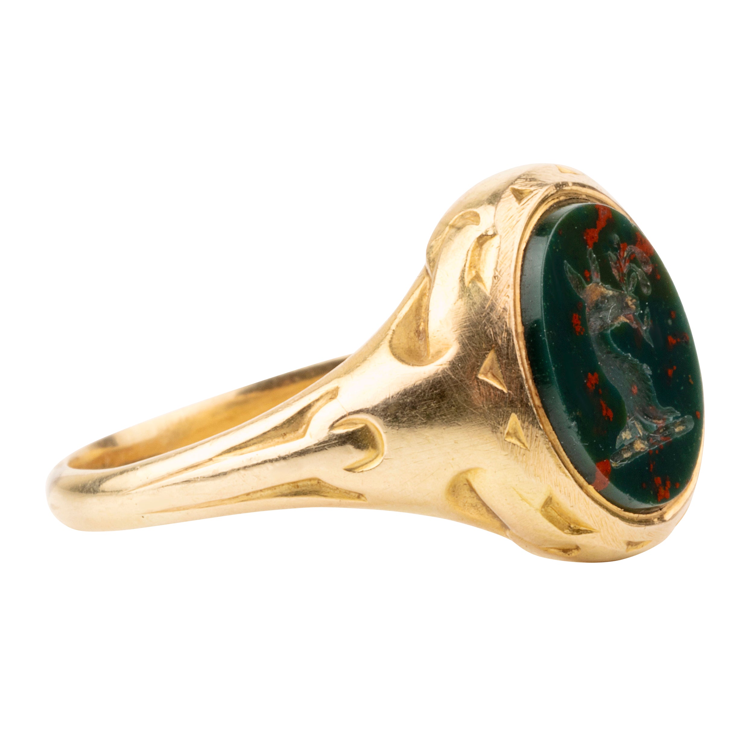 Victorian era deer intaglio signet ring, in 18k gold. Carved bloobstone intaglio depicted a deer holding a brand of leaves set in an engraved gold ring. England. Circa 1870.