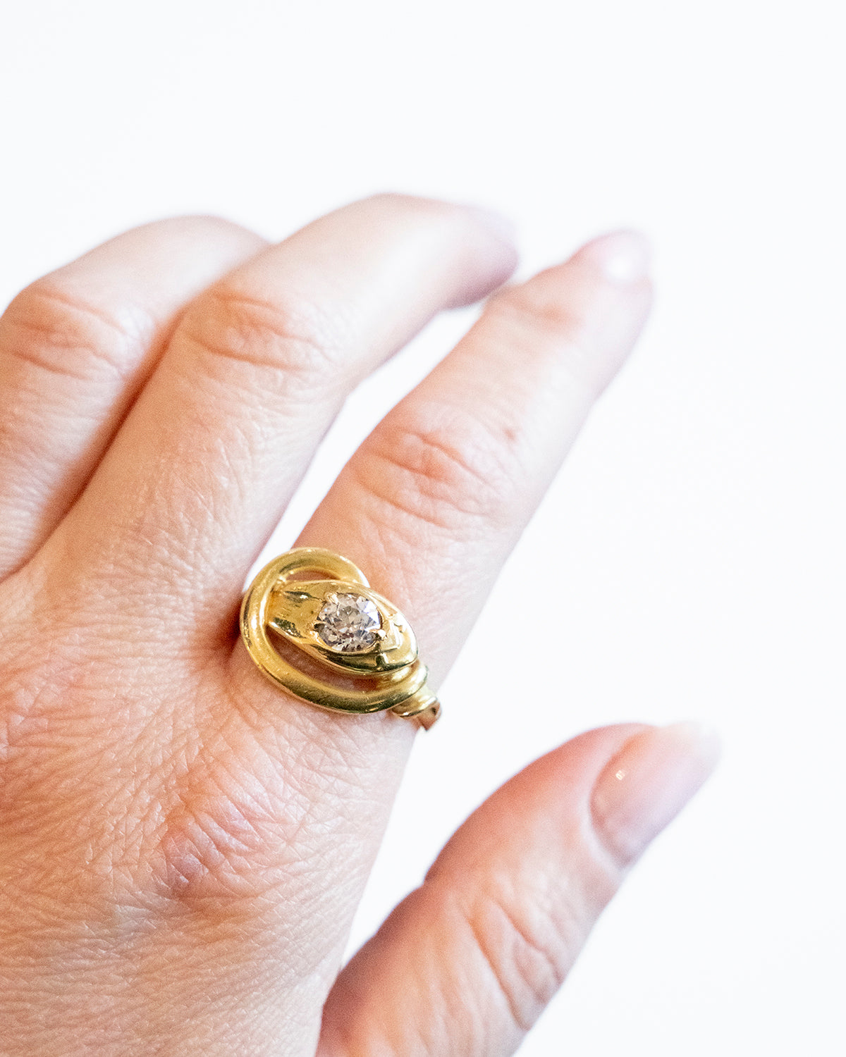 Victorian era diamond snake ring in 18k gold. An approximately 0.80 carat antique old European cut diamond in the head. English in origin. Circa 1890. Another photo of the ring being worn on a hand at another angle.
