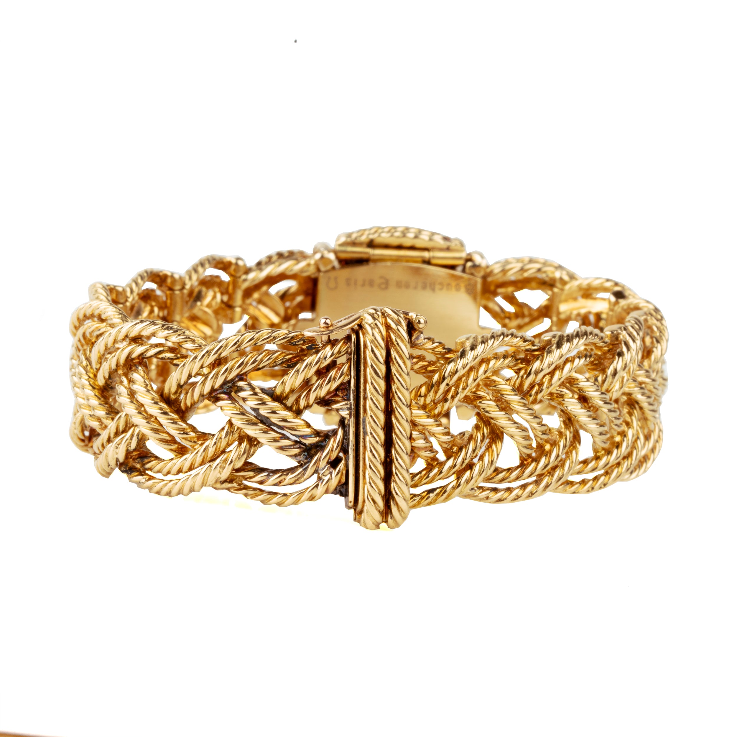 A braided 18k gold bracelet with a diamond panel that opens to reveal a diminutive watch face. The bracelet has an estimated diamond weight of 1.7 carats. Signed Boucheron, Paris. France, circa 1950.