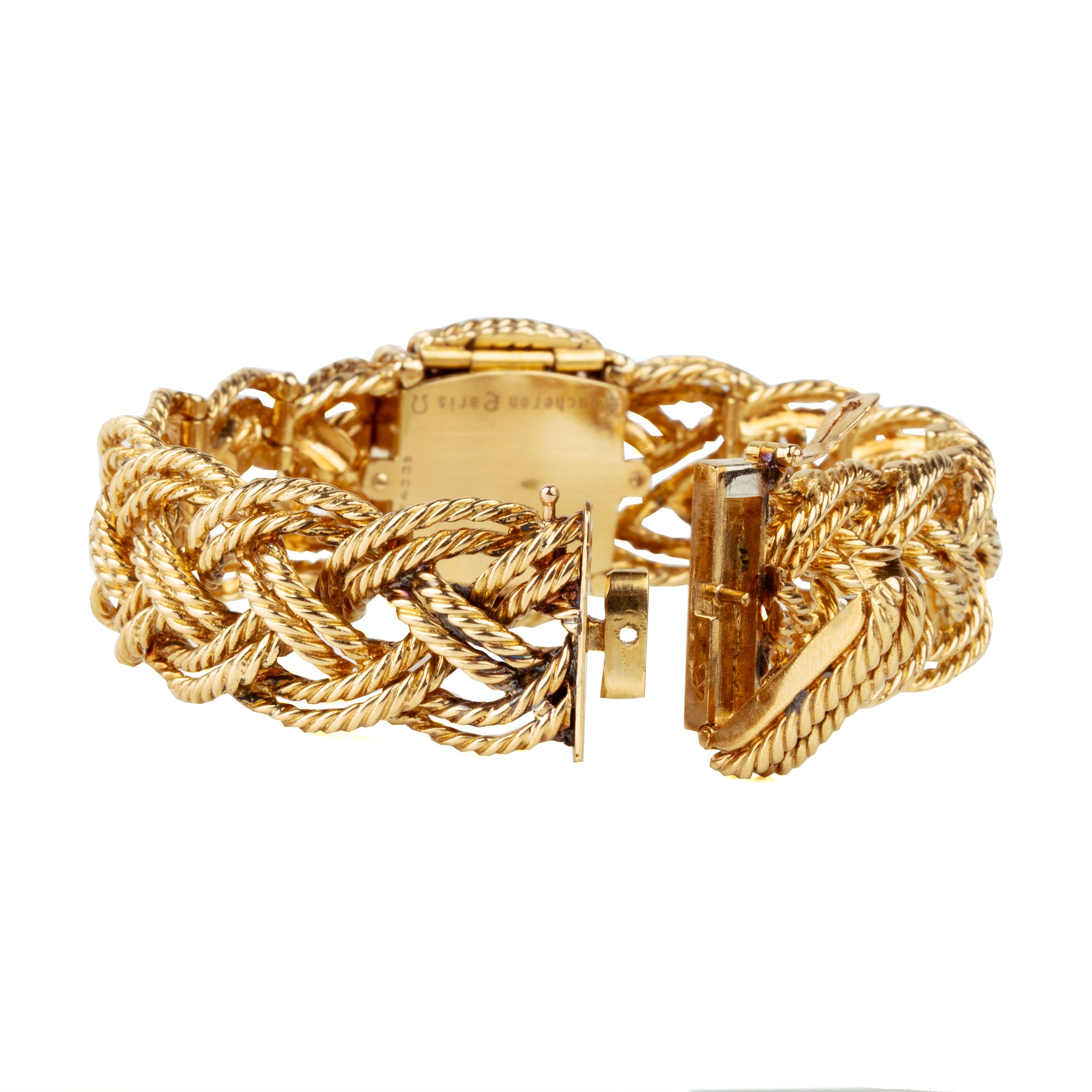 A braided 18k gold bracelet with a diamond panel that opens to reveal a diminutive watch face. The bracelet has an estimated diamond weight of 1.7 carats. Signed Boucheron, Paris. France, circa 1950.