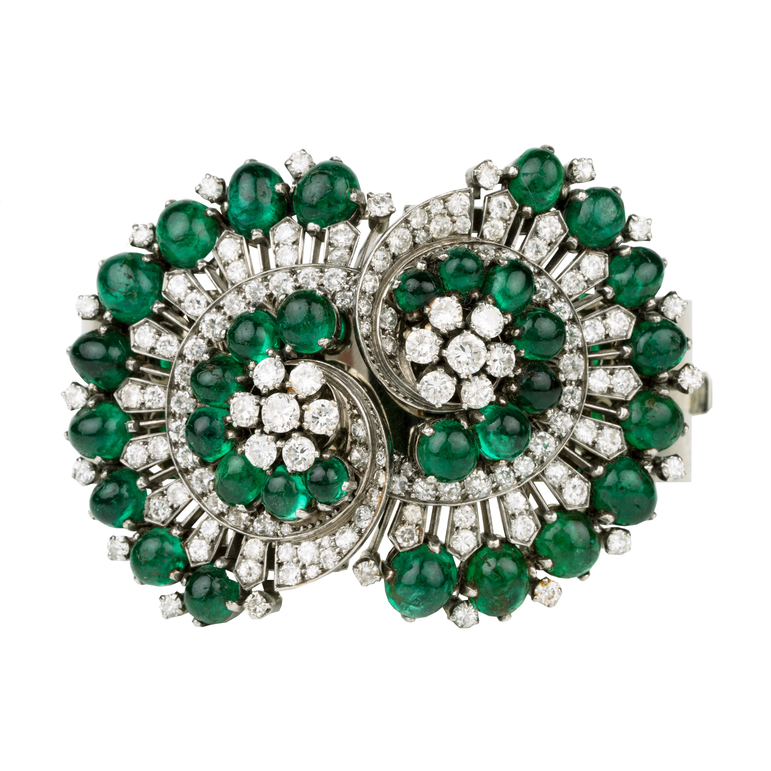 Retro emerald and diamond bracelet. This bold bangle bracelet is convertible into two separate dress clips allowing the bangle to be worn in reduced form. Bright emerald cabochon stones are set in a swirling pattern with diamonds. 18k white gold. Signed, Nieman Marcus. America, circa 1950.