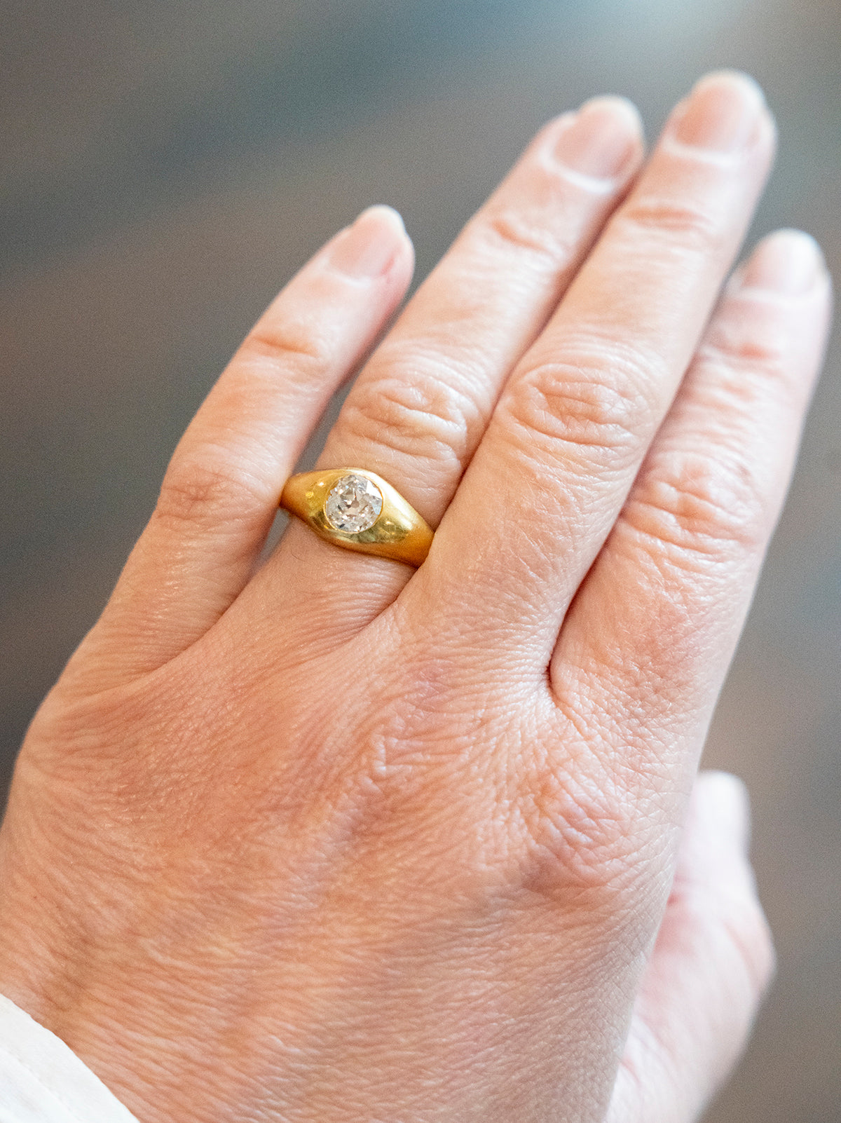 Victorian era flush set diamond solitaire ring. A lovely heavy 18k yellow gold with a single old mine cut diamond approx 1.25 cts, H color. American in origin. Circa 1890. Front view on a model.