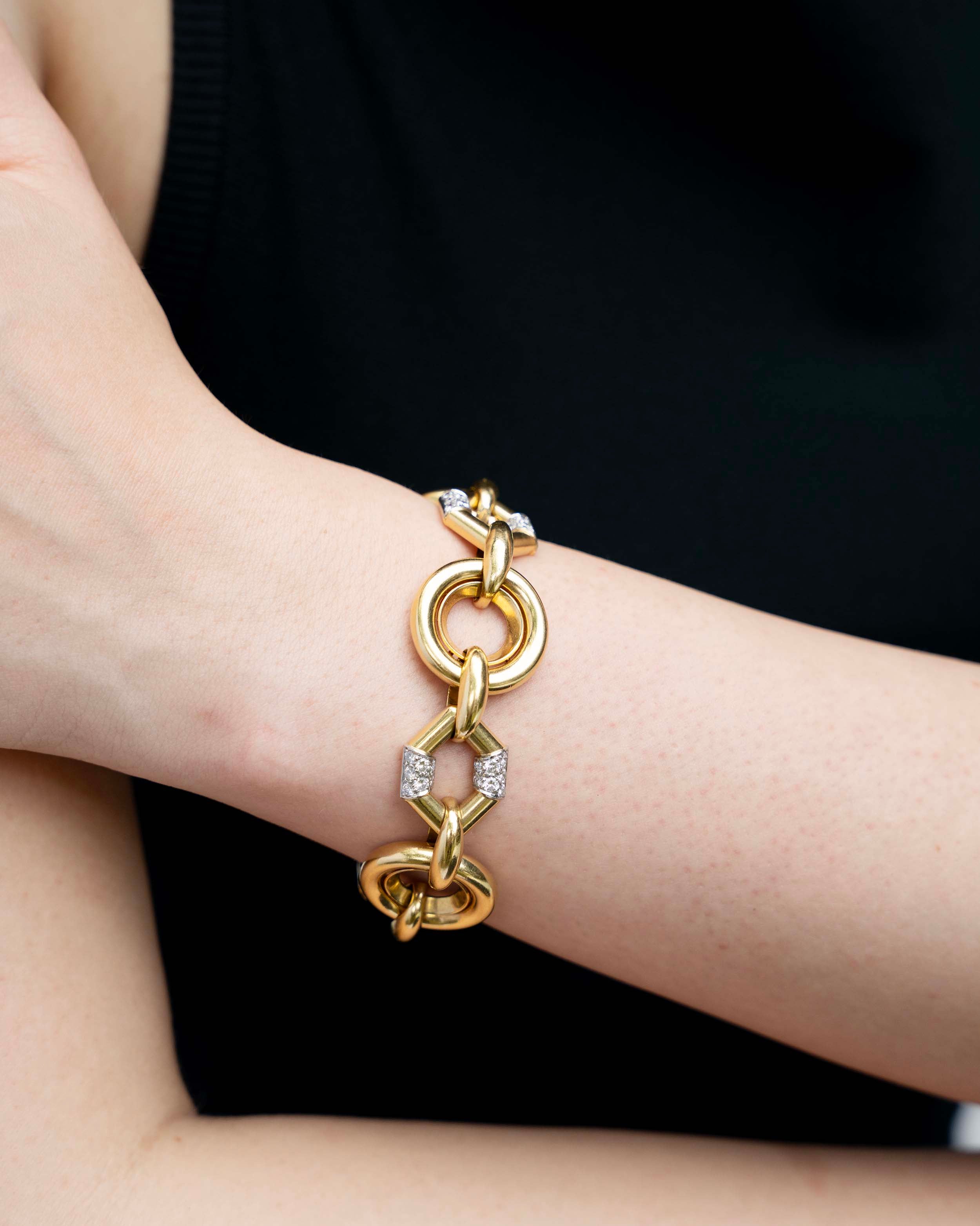 A model wear the vintage Boucheron Diamond Linked Bracelet. An enduring linked design in 18k gold. Pavé set with approximately 2 carats of diamonds in platinum. Signed Boucheron, Paris. France, circa 1970.