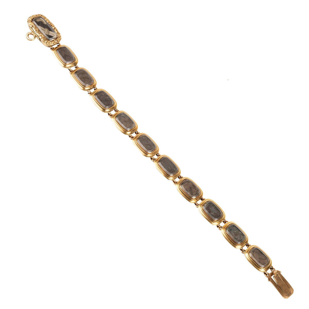Georgian-era commemorative locket bracelet in gold. The bracelet has eleven glazed compartments with well preserved braided hair and beautiful hand-engraved names. The engravings list " WN & JN, Catherine, Jane, Isabella, Anne, Mary, William Henry, Sarah, Frances, George Stewart, Caroline". Likely including all of the children of the original owner. English in origin. Circa 1820.