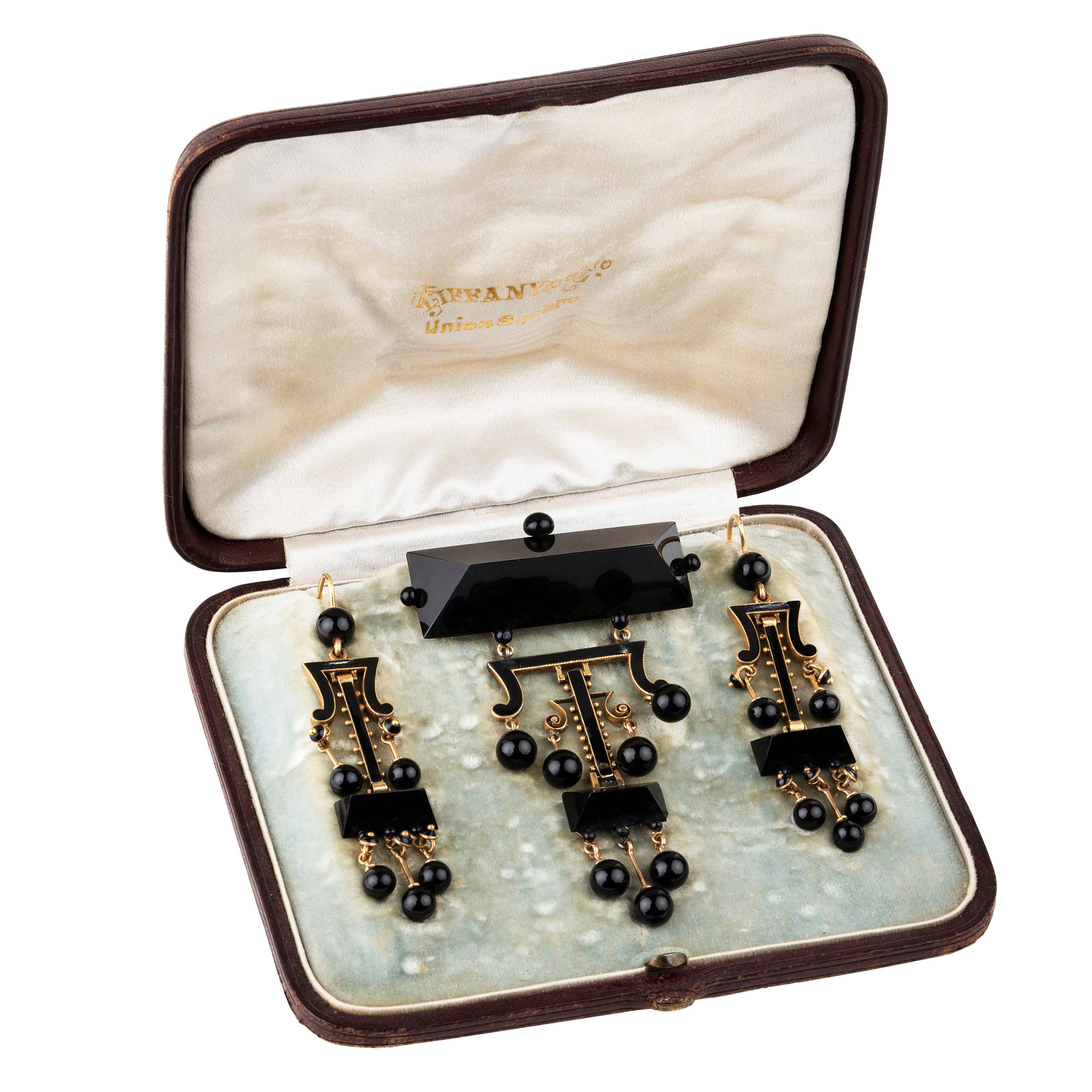 19th Century Tiffany & Company onyx earrings and brooch, in 18k gold. Carved onyx and black enamel details with the original box. American. Circa 1870.