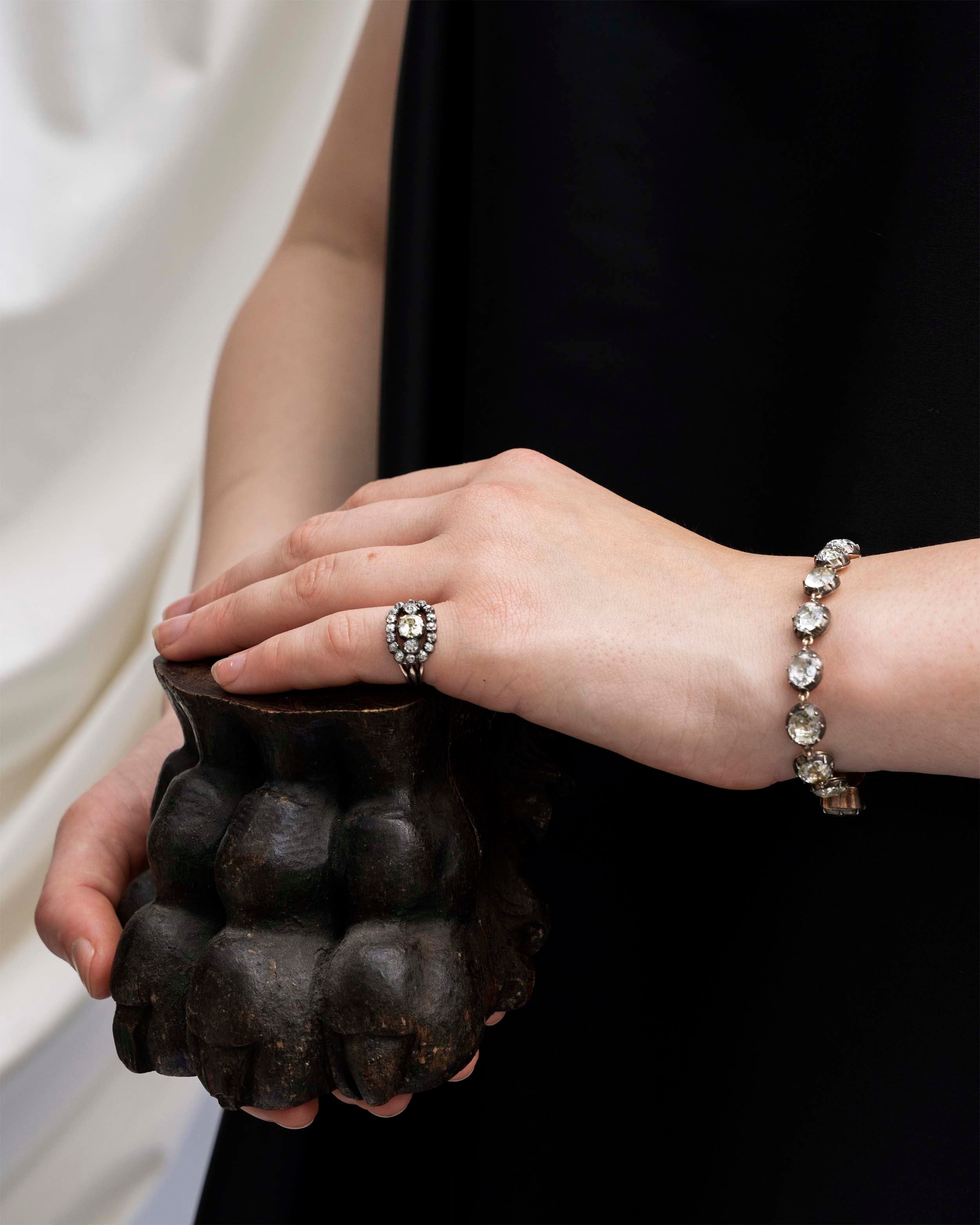 In the same form as the highly desired paste rivière necklaces, this bracelet was likely once part of a larger parure. The stones are not leaded glass paste but rock crystal quartz. Each is slightly different in size and proportion. Set in silver-topped gold collet settings. England, circa 1820. The bracelet on a model wearing a diamond ring.