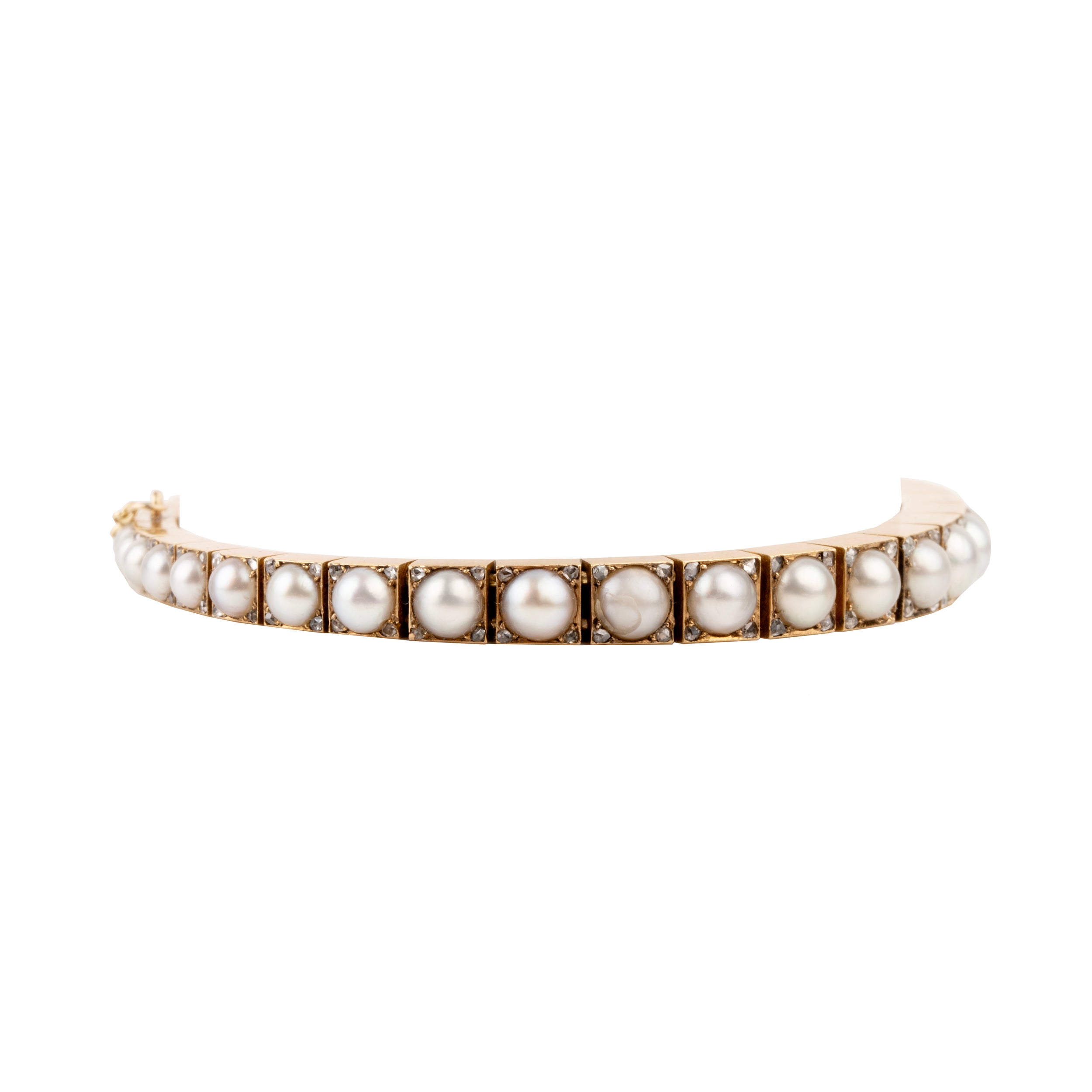 Edwardian era pearl and diamond line bracelet. White split pearls are set in 18k yellow gold. Each pearl is pointed with four rose cut diamonds in square settings. England, circa 1910.