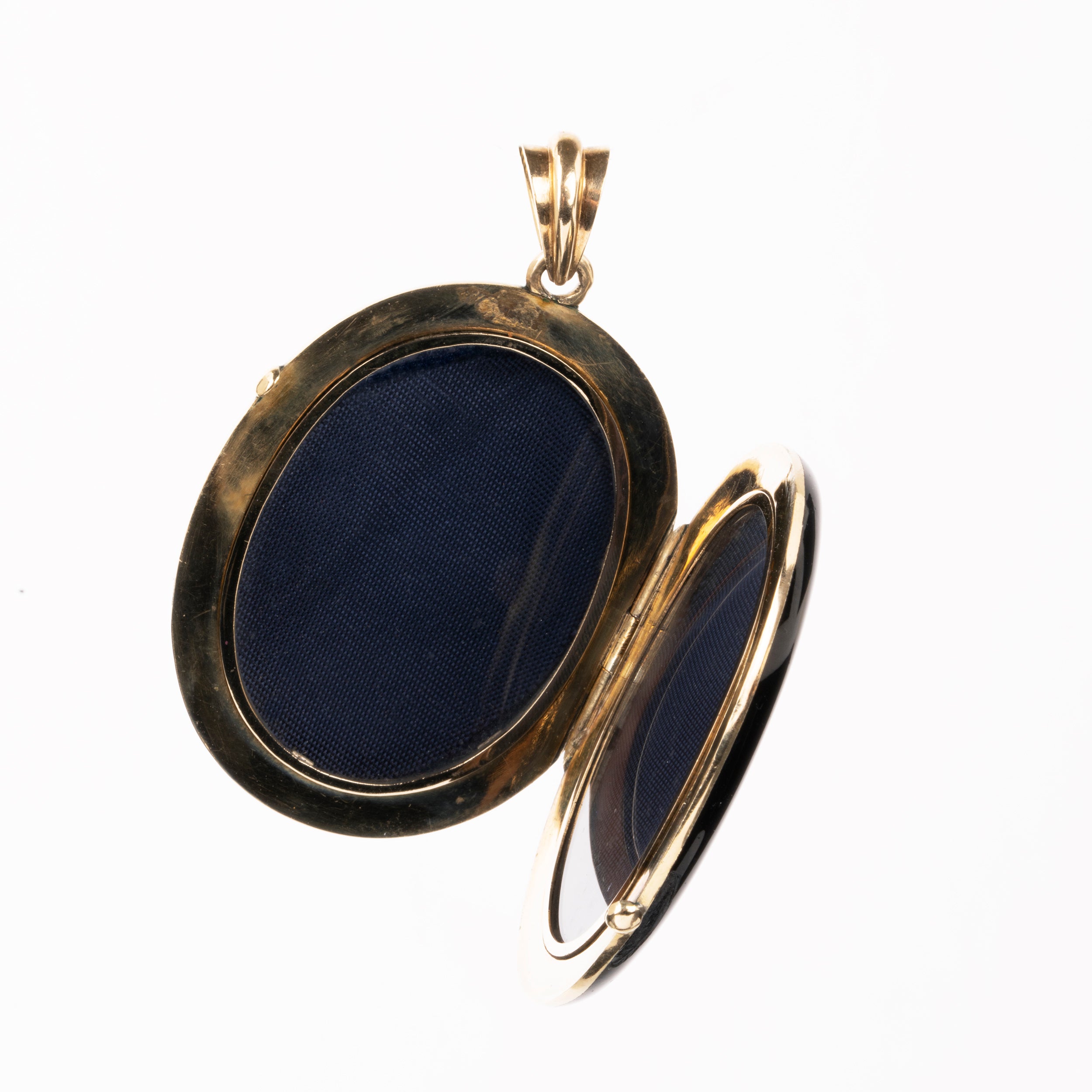 A bold black enamel locket with a pearl starburst motif. The locket is crafted in 18k gold. It opens to reveal two compartments for photographs or keepsakes. England, circa 1870.
