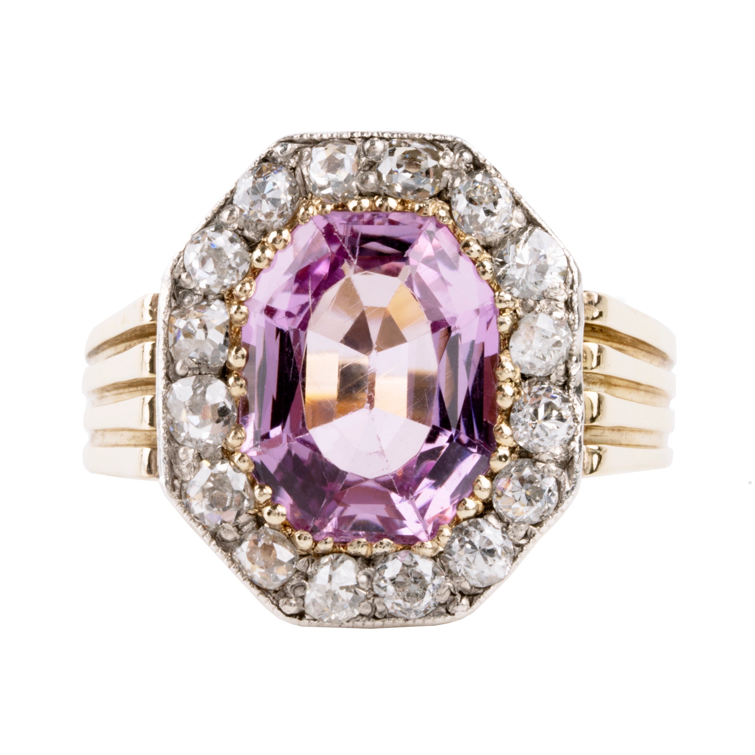 Striking ring with a large, vibrant pink precious topaz stone. It has very crisp clarity and rich color. The photographs do not capture the depth of color. There are sixteen mixed-cut antique diamonds surrounding the primary stone. Old Mine and old European cuts are set in platinum, while the rest of the ring is in 18k gold. England, circa 1900. Front view.