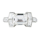 A contemporary design constructed a seven-stone ring with classical techniques. Six baguette diamonds surround an emerald cut diamond. This ring features a GIA-certified emerald cut diamond, 2.01 carats, H color, and VS1 clarity. There are six vintage baguette diamonds, approximately 1.12 carats in total diamond weight, H color, and VS2 clarity. Handcrafted in platinum.