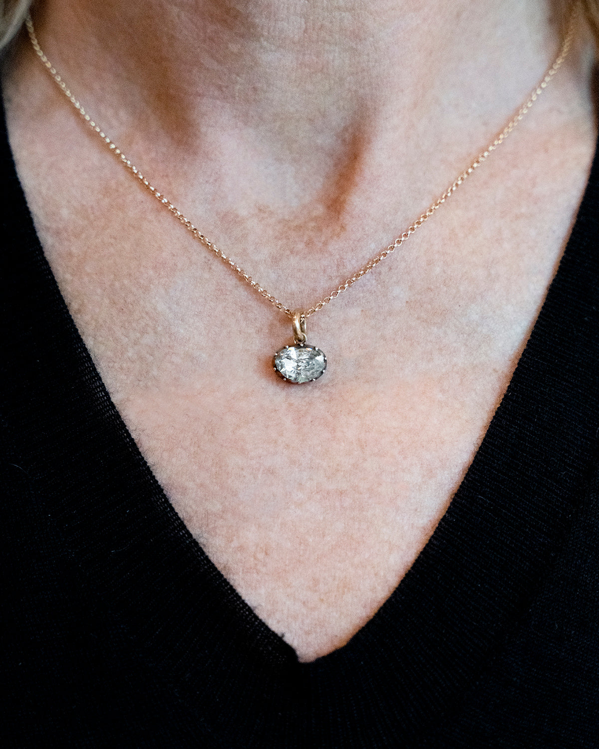 Georgian era rose cut diamond pendant necklace. The bright rose cut diamond is a subtle heart-shape, set in a foiled closed-back setting. Originally part of a larger piece of jewelry, it was later converted into a simple charm pendant. The diamond weighs approximately .95 carats. The diamond is quite flat and faces- up like a two-carat stone. Found in Paris. Circa 1820. The diamond is hanging from a delicate gold chain. The necklace being worn by a model to show the scale of the piece.