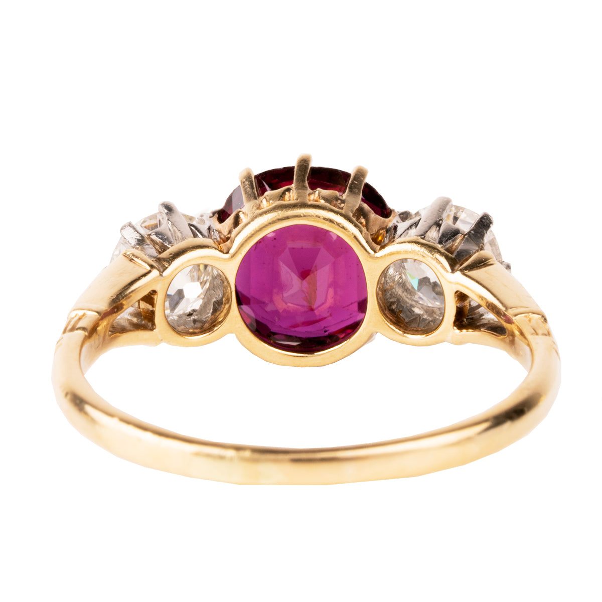 A classic ruby and diamond ring three stone ring. The ring features a natural red 2.11 carat ruby certified to have no treatment and be of Thai origin. The primary stone is flanked by two old European cut diamonds weighing approximately .5 carat each. The ring is set in 18k yellow gold and platinum.  English in Origin. Circa 1910. The stone holds a certificate from GCS laboratory in London. Certificate number:5784-2538. Backside view.