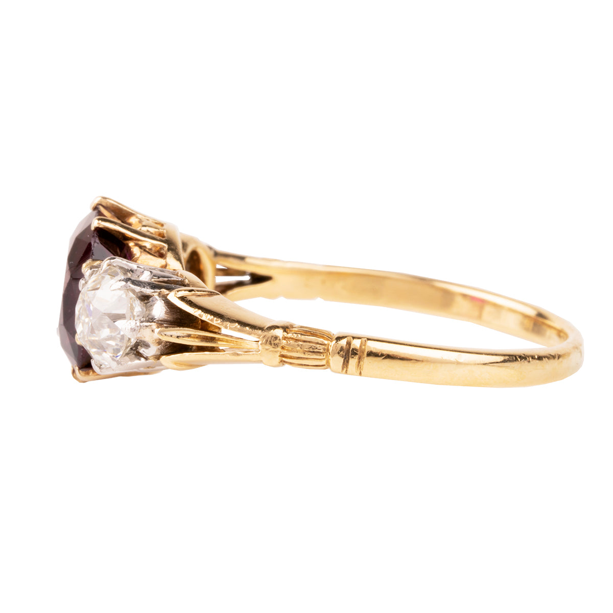 A classic ruby and diamond ring three stone ring. The ring features a natural red 2.11 carat ruby certified to have no treatment and be of Thai origin. The primary stone is flanked by two old European cut diamonds weighing approximately .5 carat each. The ring is set in 18k yellow gold and platinum.  English in Origin. Circa 1910. The stone holds a certificate from GCS laboratory in London. Certificate number:5784-2538. Side view.