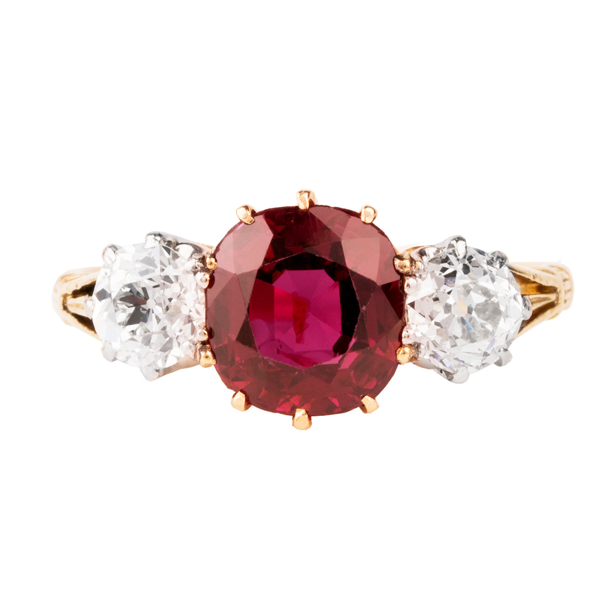 A classic ruby and diamond ring three stone ring. The ring features a natural red 2.11 carat ruby certified to have no treatment and be of Thai origin. The primary stone is flanked by two old European cut diamonds weighing approximately .5 carat each. The ring is set in 18k yellow gold and platinum.  English in Origin. Circa 1910. The stone holds a certificate from GCS laboratory in London. Certificate number:5784-2538. Front view.