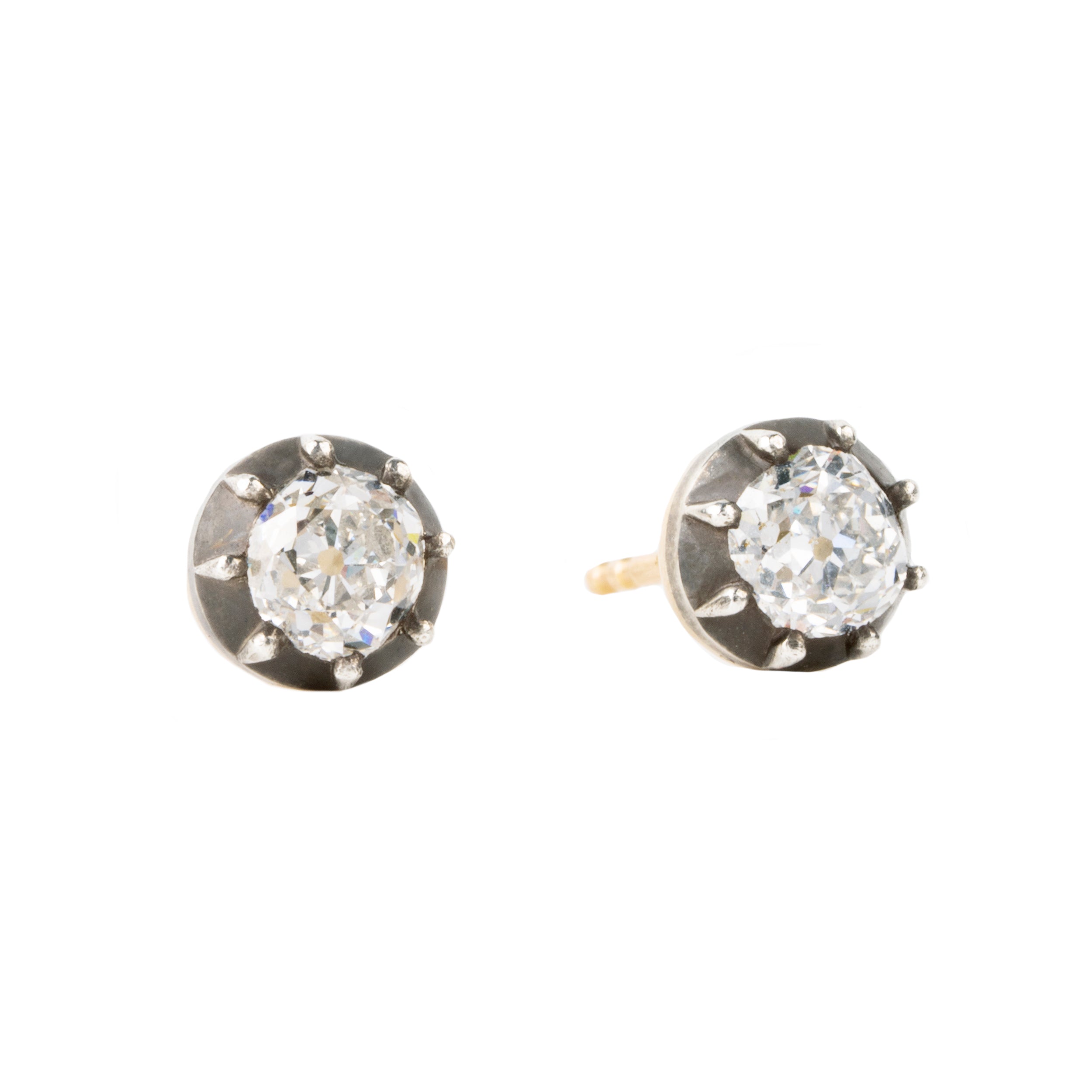 Our design for these earrings is inspired by Georgian and Victorian Era cutaway settings. Entirely hand fabricated they feature silver topped gold cutaway collet settings. This is a labor-intensive setting technique common in 18th and 19th century. These demure earrings feature two old mine cut diamonds, approximately 1.06 carats in total diamond weight , H-I color and SI1 / SI2 clarity. Hand engrave Bell & Bird markers mark. Side view.