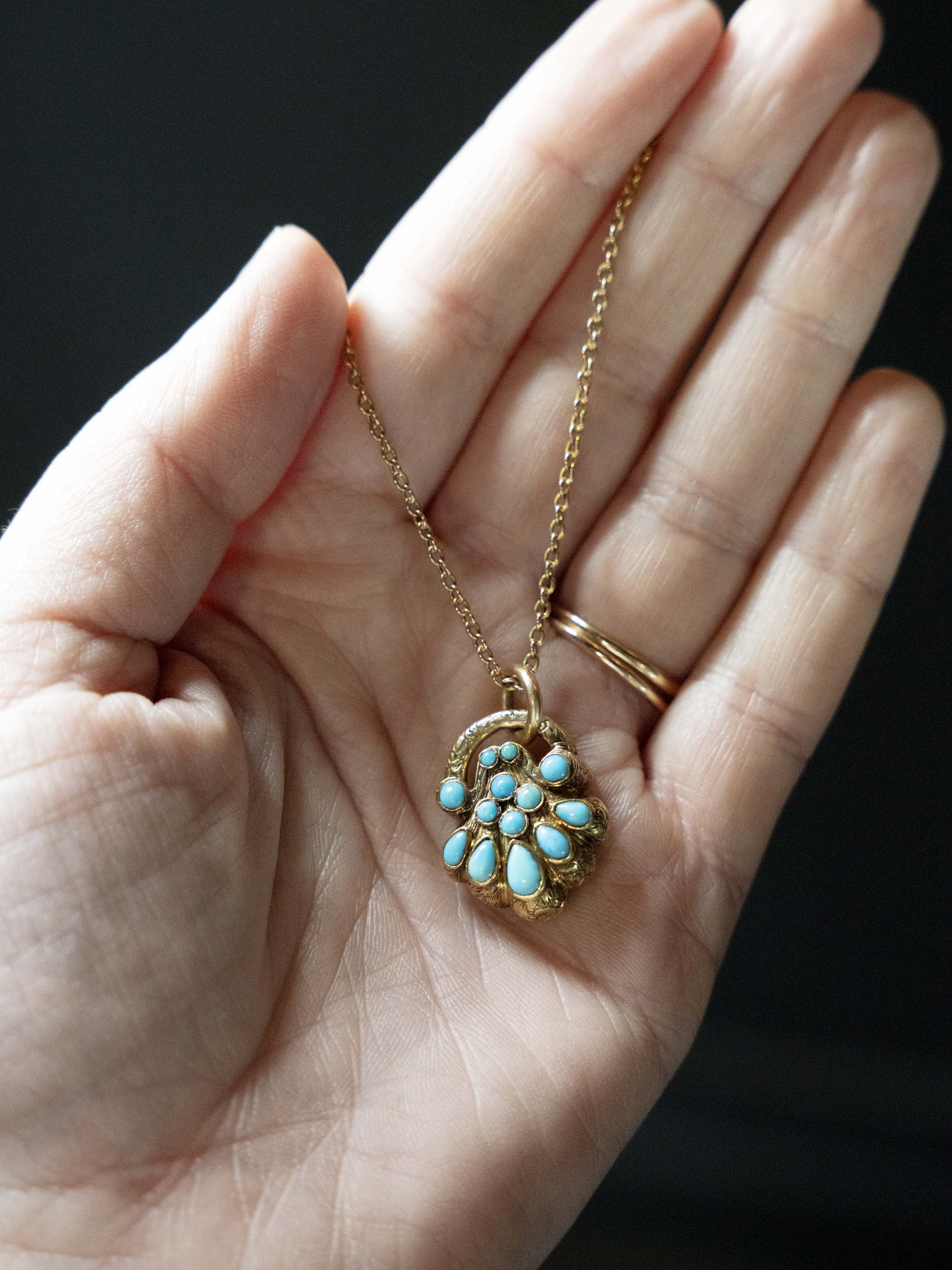Early Victorian era turquoise padlock locket in 15k gold. It is in the form of a shell with Persian turquoise and a glazed compartment. English in origin. Circa 1840. Hanging on an antique 15k gold turquoise beaded ball chain.