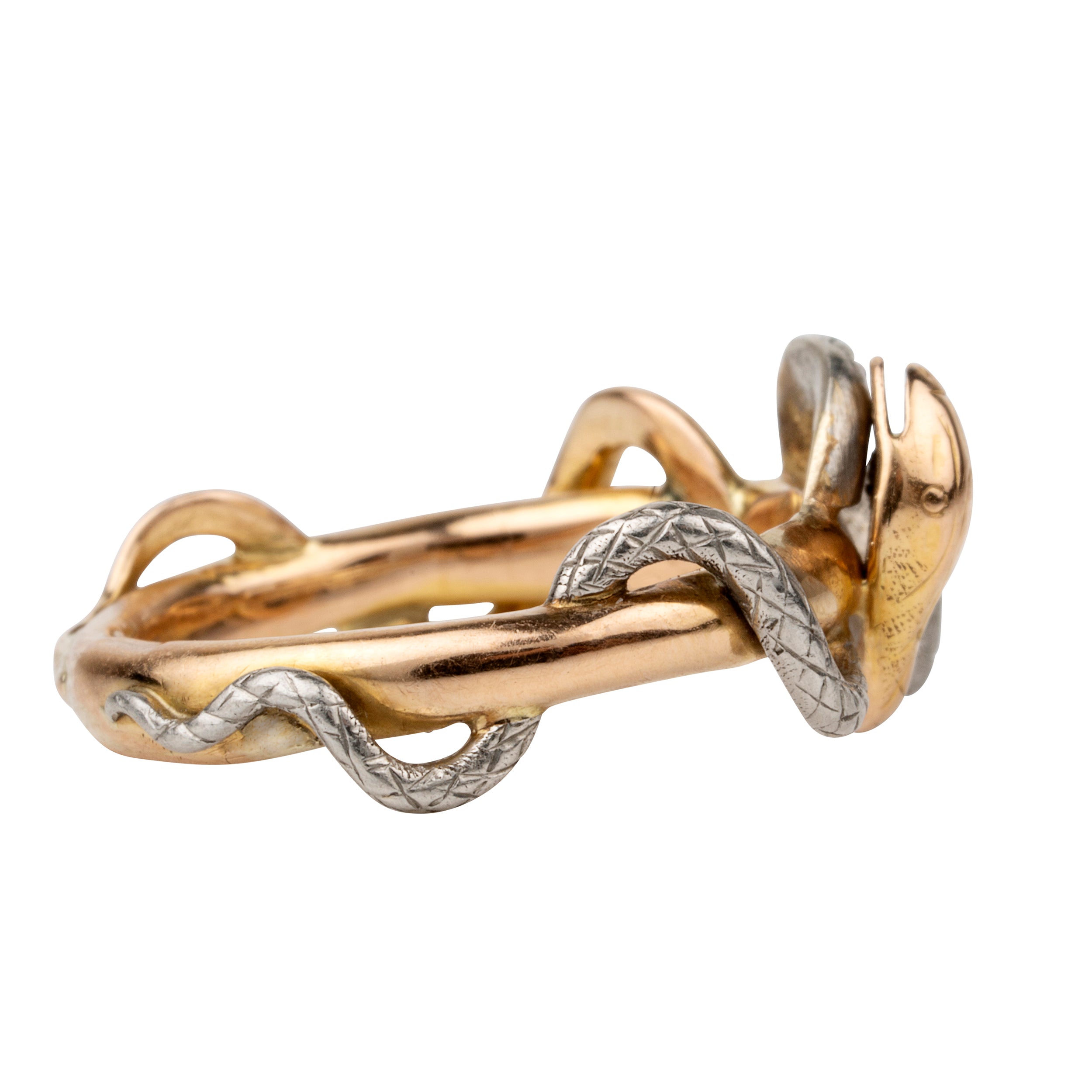 Turn of the century entwined snake ring, in platinum and gold. Hollow construction. There is a small dent on the band next to the platinum snake head. England. Circa 1910.