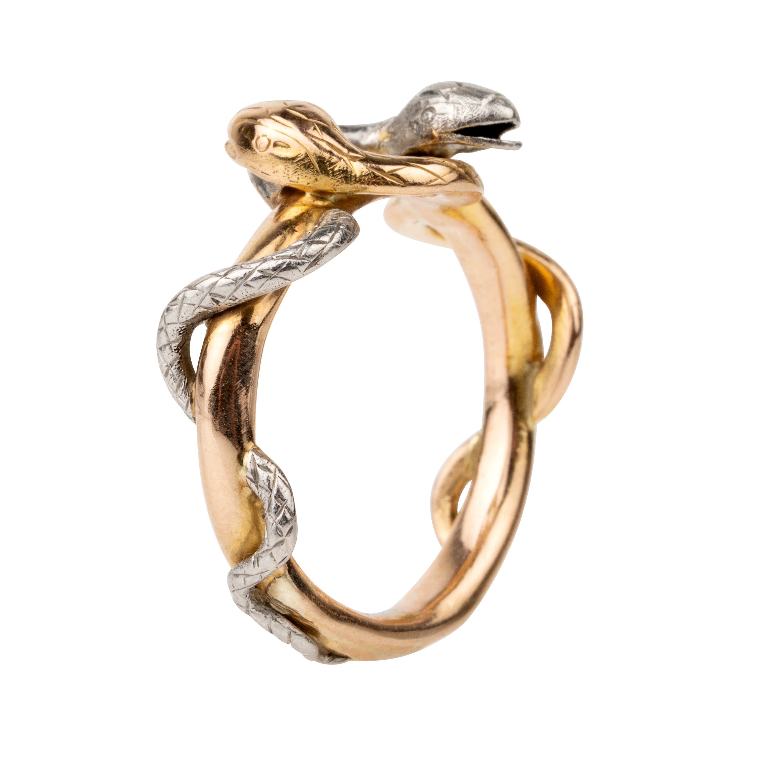 Turn of the century entwined snake ring, in platinum and gold. Hollow construction. There is a small dent on the band next to the platinum snake head. England. Circa 1910.