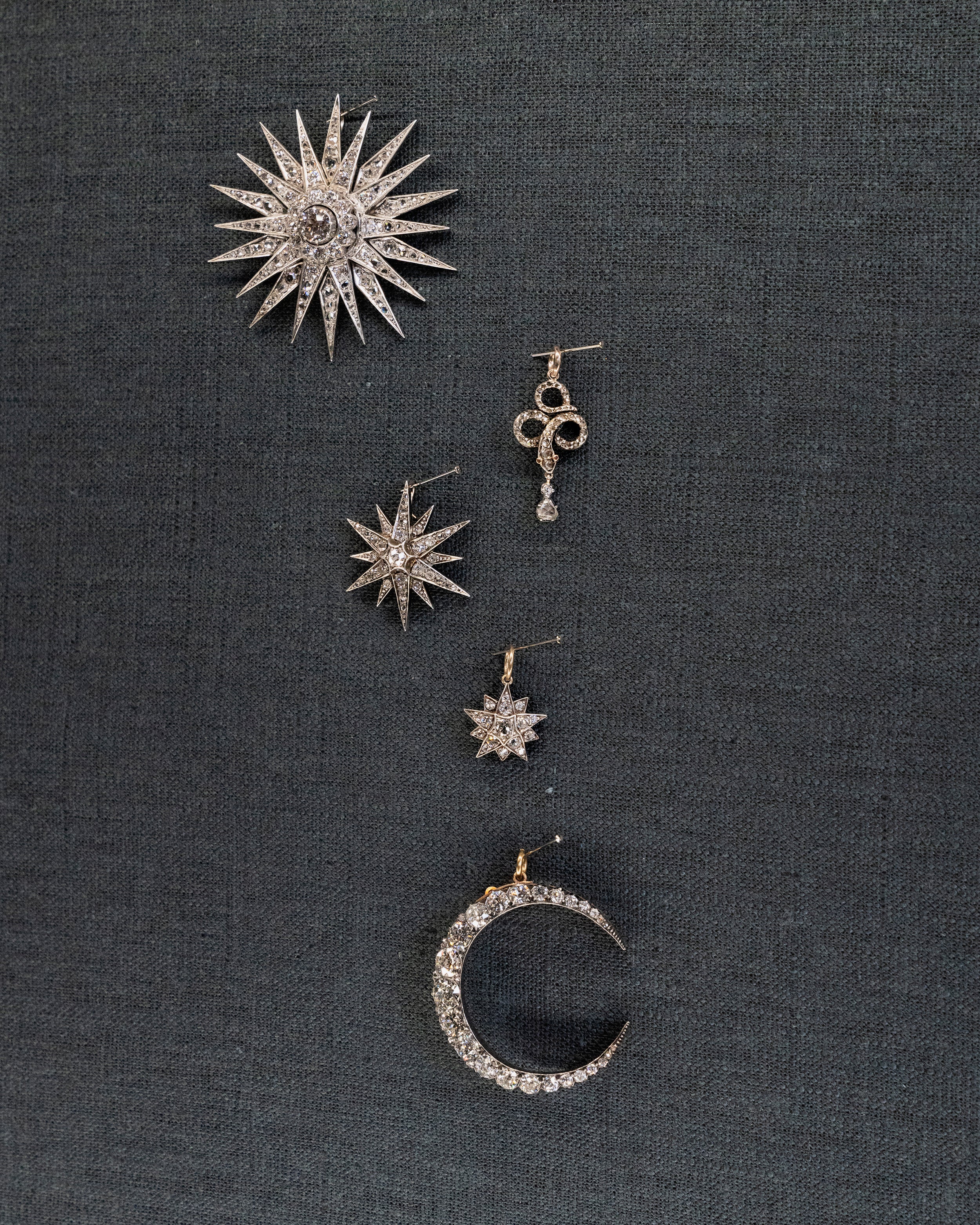 A lovely example of a 19th-century star pendant in silver-topped gold. It is a smaller scale than typically seen and very wearable. Sixteen bright old mine cut diamonds, with an estimated total diamond weight of two carats, English in origin. Circa 1880. Hanging on a wall with other diamond pieces.