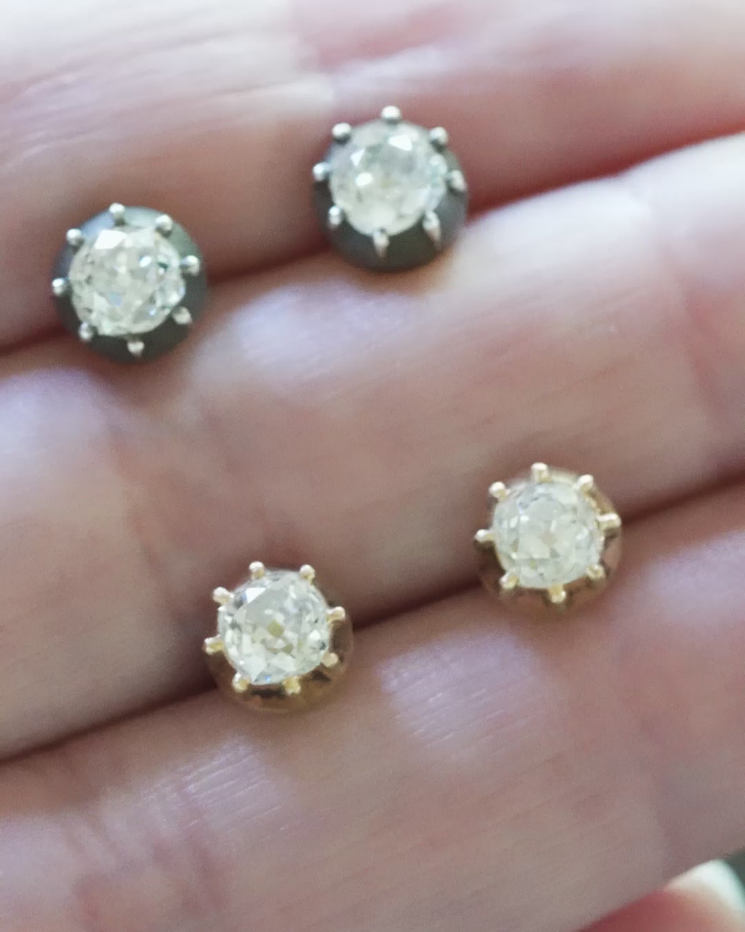 Video of Bell & Bird cutaway diamond earrings in silver and gold being held by a hand to show the scale of the earrings.