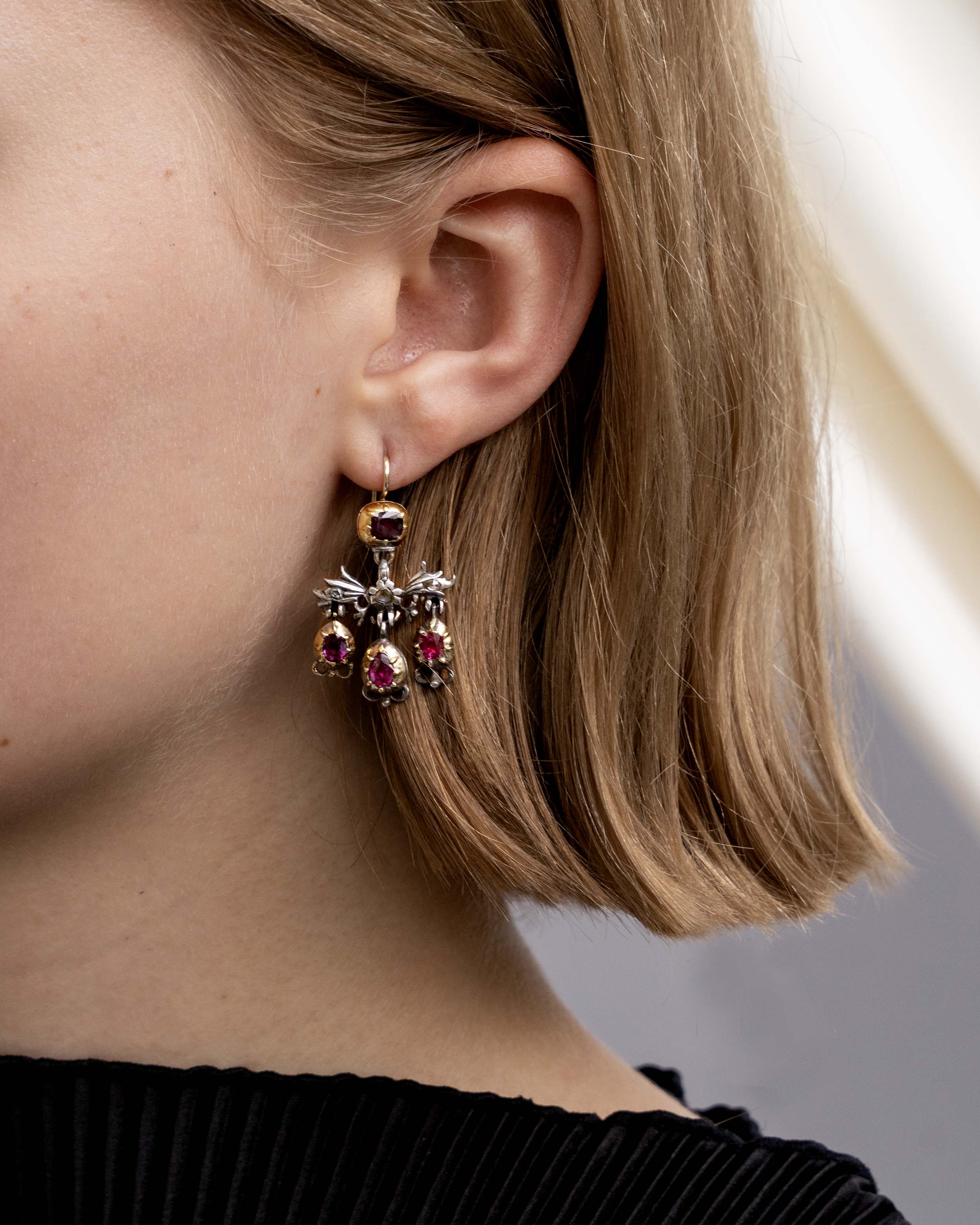 The girandole design consists of three pear-shaped drops suspended from a central bow motif. The design was popular towards the end of the 17th century through the 18th century. When the style's popularity diminished, elements were often disassembled and utilized in reduced form, making examples in original form quite rare. Rose-cut diamonds are set into the central element in silver, while the ruby stones are set in 18k gold. Continental Europe, circa 1760. Being worn by a model.