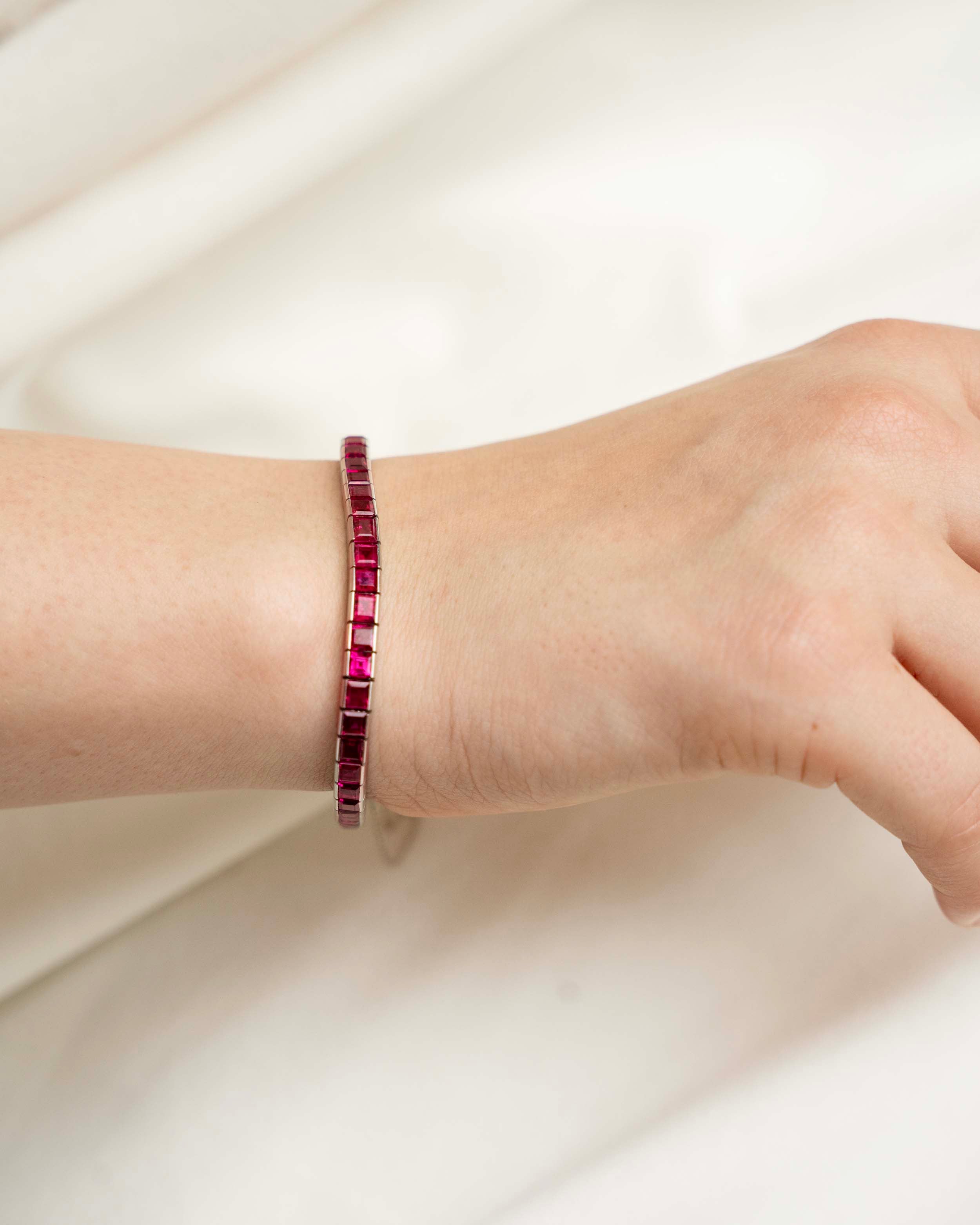 Art Deco ruby line bracelet. A fine early 20th-century platinum line bracelet. Natural deep red step-cut rubies are primarily Burmese in origin. Approximated at 11 carats in total stone weight. America, circa 1920. The bracelet on a model bracelet.