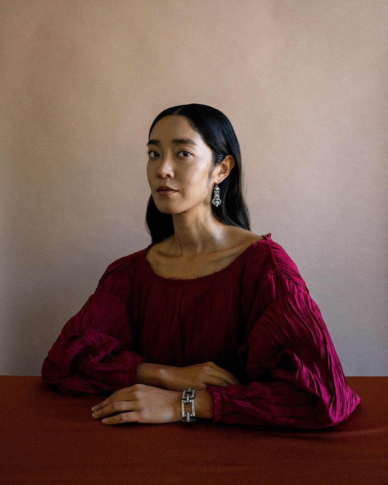 A model in a red dress wearing antique jewelry. Modeling the important 19th century old mine cut diamond bracelet. Over 150 elongated old mine cut diamonds are set in a silver topped gold setting. The contemporary feel of this bracelet along with its fine materials and craftsmanship dating to the 1850’s combine to make this bracelet so special. English in origin.