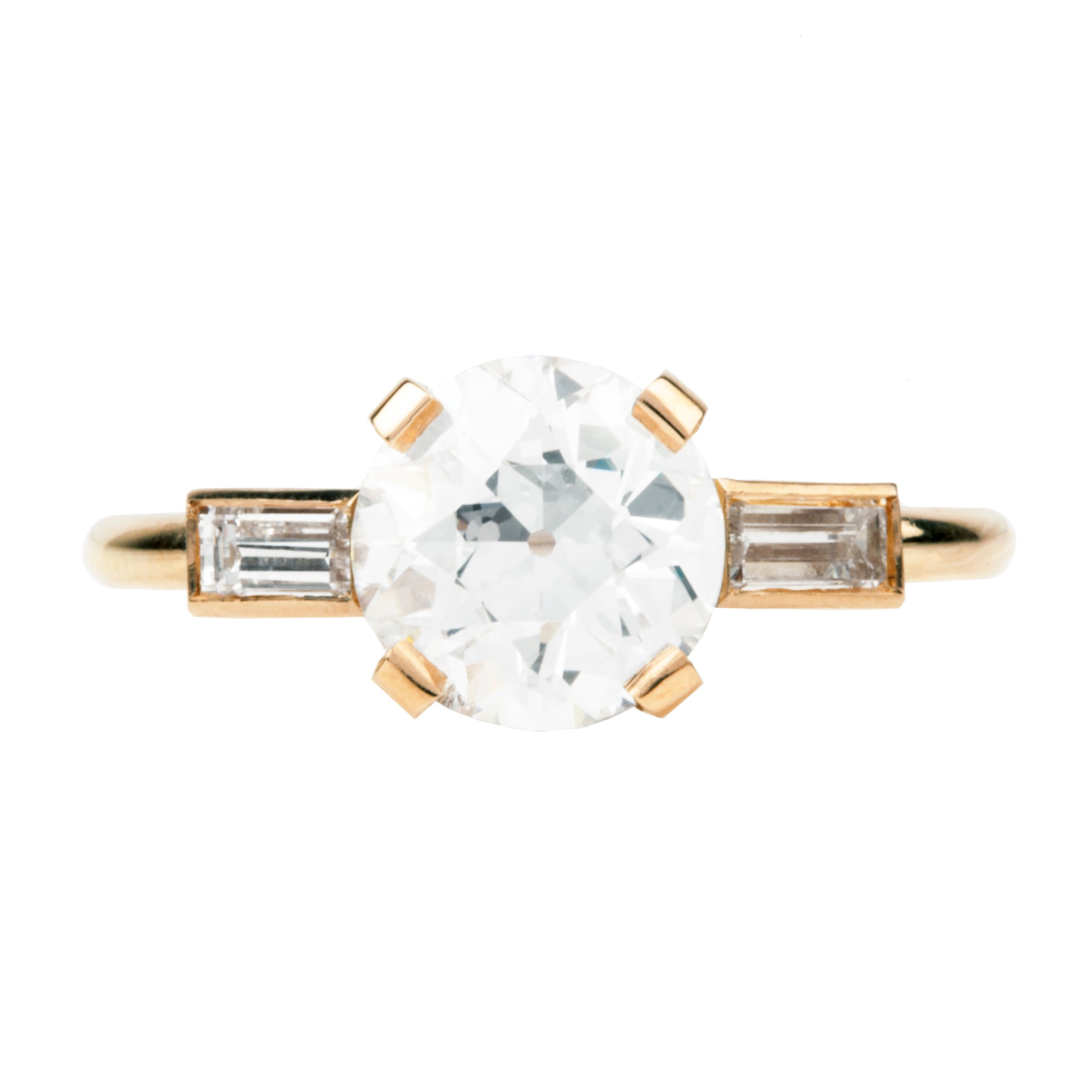 An elegant ring featuring a central old European cut diamond in a simple four-prong setting, flanked by two straight baguettes, all in a custom blend of 18K rose gold.