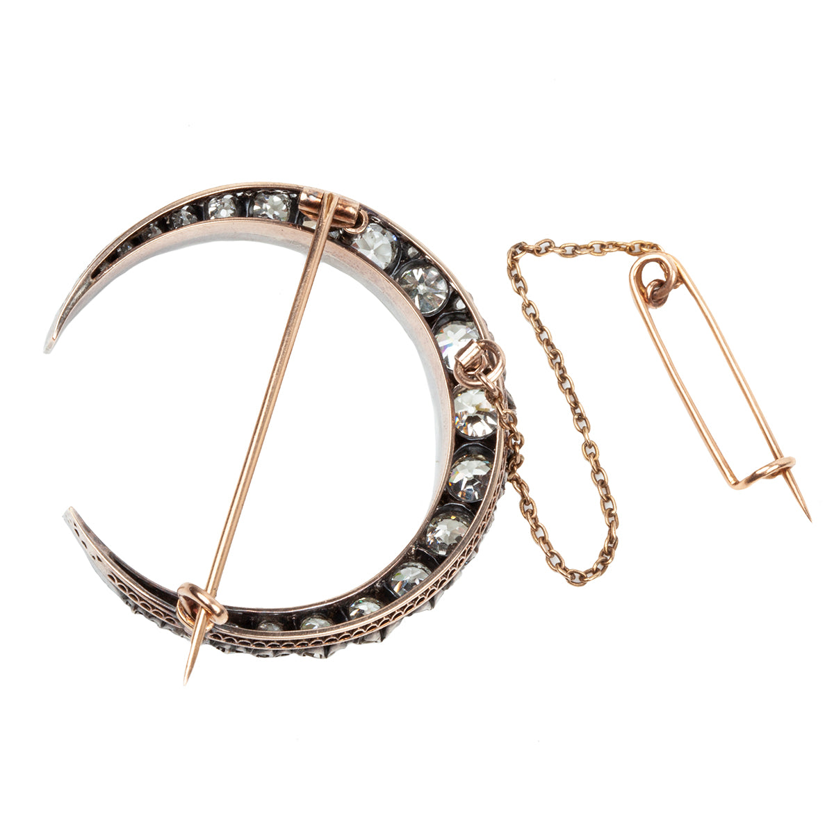 A slender arc of light executed in glittering old mine cut diamonds. Crafted in a silver-topped gold setting this piece has been masterfully constructed to function as a brooch and a pendant with the original fixtures still intact. Approximately 7.20 carats in total diamond weight. English in origin. Back view showing the brooch details.