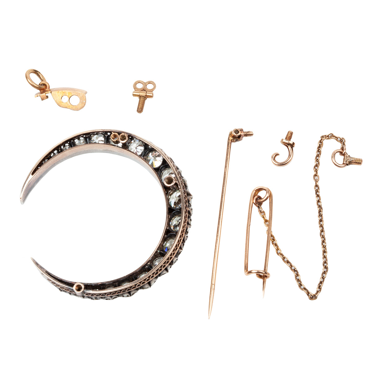 A slender arc of light executed in glittering old mine cut diamonds. Crafted in a silver-topped gold setting this piece has been masterfully constructed to function as a brooch and a pendant with the original fixtures still intact. Approximately 7.20 carats in total diamond weight. English in origin. All the elements seperated.