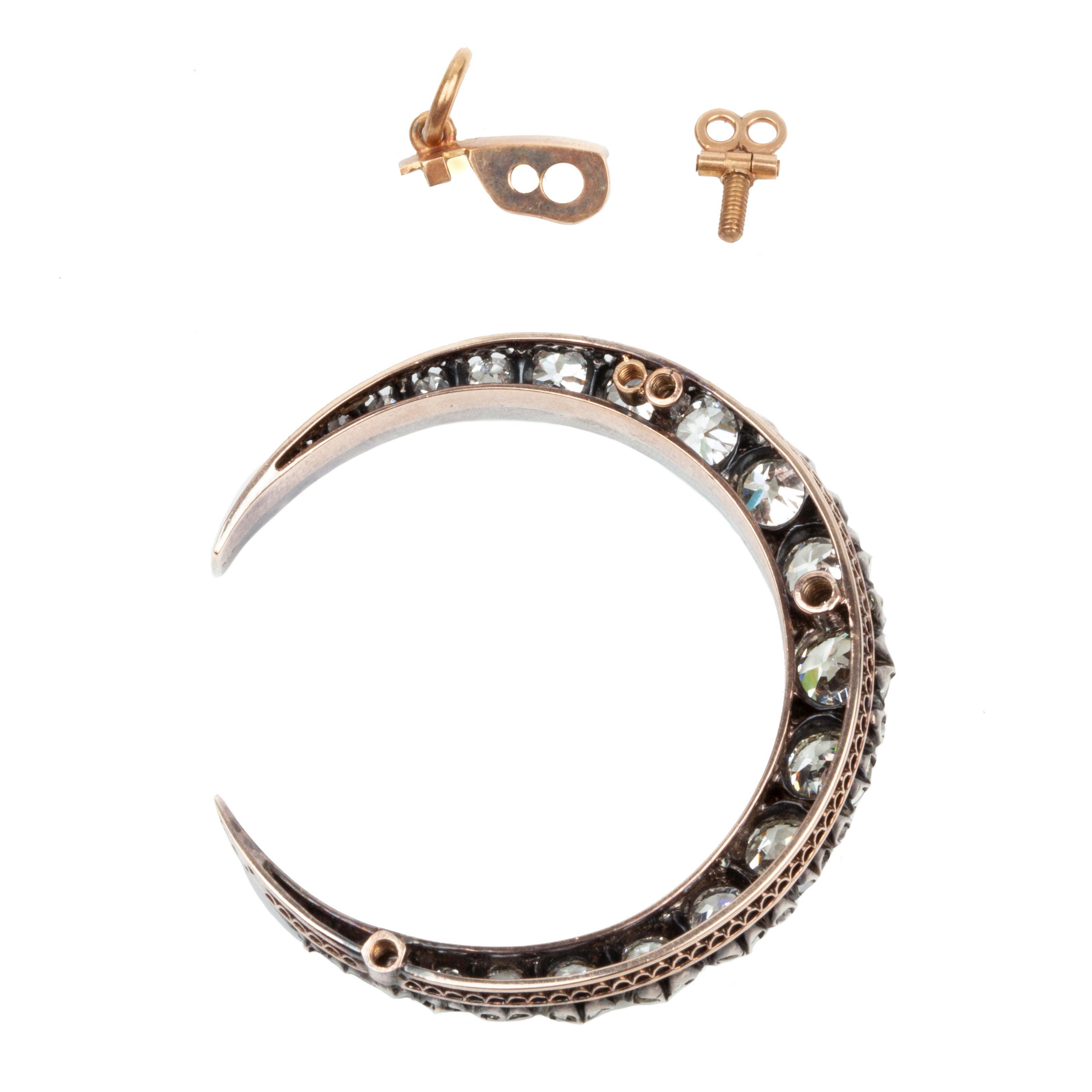 A slender arc of light executed in glittering old mine cut diamonds. Crafted in a silver-topped gold setting this piece has been masterfully constructed to function as a brooch and a pendant with the original fixtures still intact. Approximately 7.20 carats in total diamond weight. English in origin. The back view.