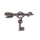 Tiny Victorian era Rose cut diamond arrow brooch with the tiniest key hanging from a laurel wreath. Silver topped gold with original clasp fixture. English in Origin. Circa 1860. Close-up view.