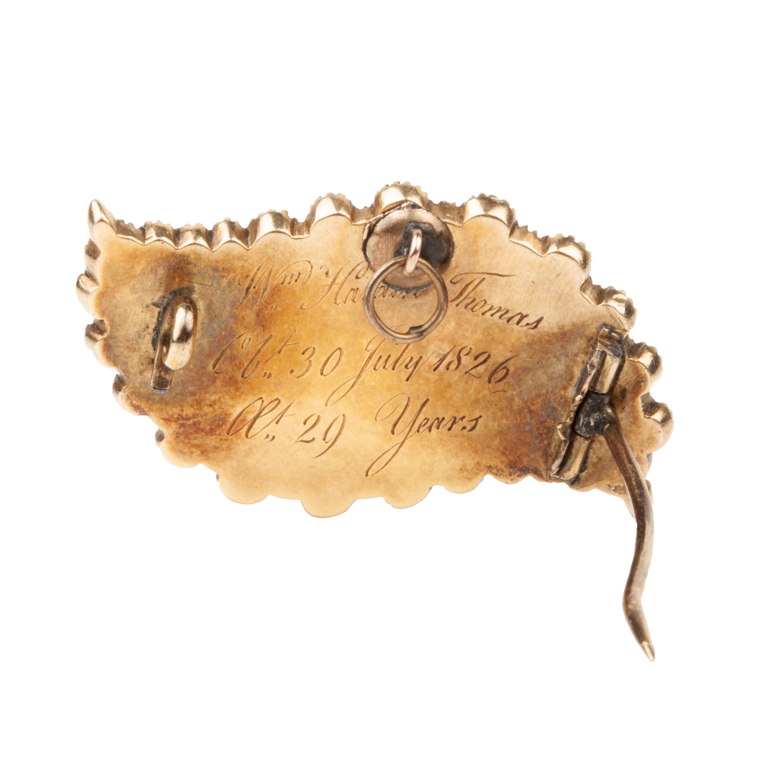 Georgian era brooch in the shape of an eye, in 18k gold with natural pearls and black enamel details. There is a central locket compartment that contains finely woven hair. A very sentimental brooch as the Victorians used seed pearls to signify tears. Engraved "W Harris Thomas. OB 30 July 1826, AE 29 Years". English in origin. Circa 1820. Close-up for the engraving on the backside.