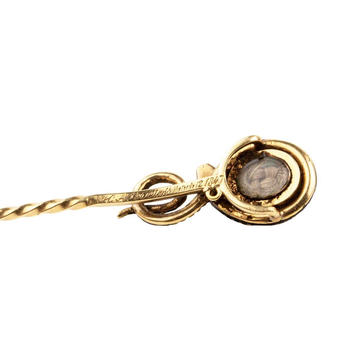 Early Victorian era mourning stick pin with enamel snake and carved hardstone urn, in gold. The mourning piece has engraved "H A& Levett ob March 12 1847". The original woven hair is the backside locket compartment. Can be worn as an accessory or displayed on the wall as a decorative piece. English in origin. Held in hand to show scale. Close up view of the backside of the pin.