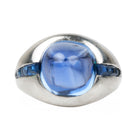 Early 20th-century platinum ring with unique high-domed Sugarloaf cabochon sapphire in a heavy platinum setting. Approximately 5 carat no-heat Ceylon Sapphire with AGL certificate indicating origin and no treatment of any kind. Beautiful cornflower blue with matched step-cut side stones. The center stone has fantastic clarity. Circa 1920.