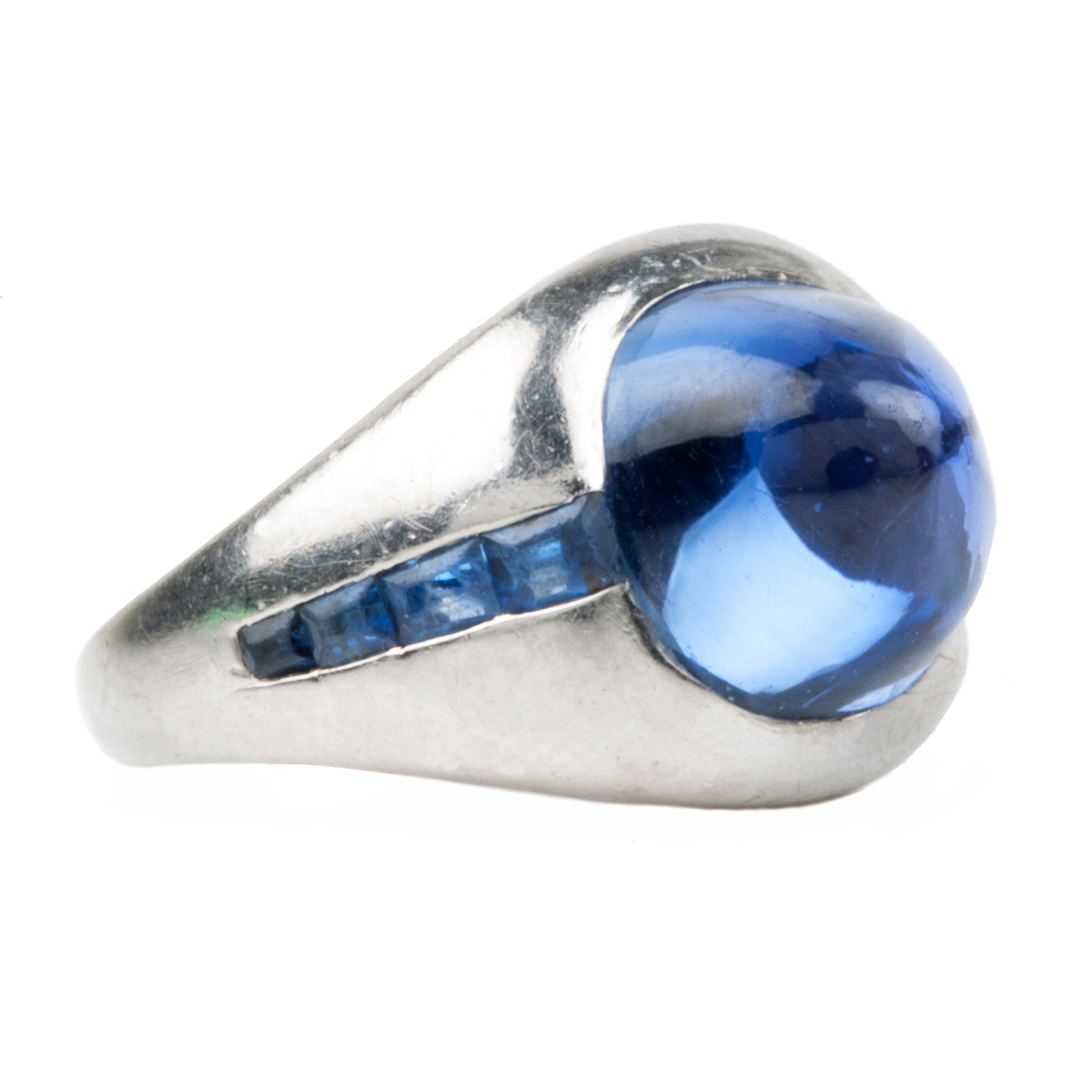Early 20th-century platinum ring with unique high-domed Sugarloaf cabochon sapphire in a heavy platinum setting. Approximately 5 carat no-heat Ceylon Sapphire with AGL certificate indicating origin and no treatment of any kind. Beautiful cornflower blue with matched step-cut side stones. The center stone has fantastic clarity.Circa 1920.