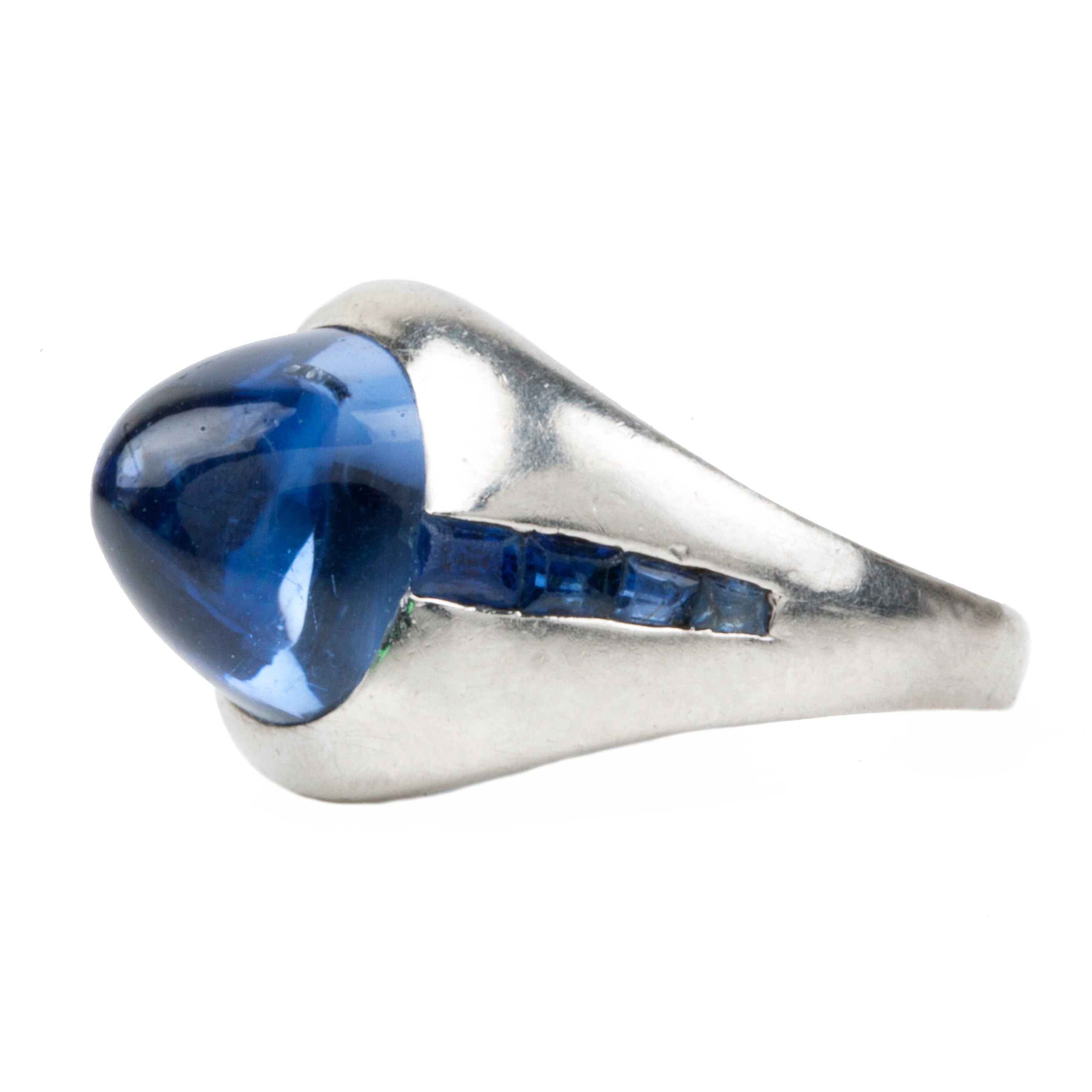 Early 20th-century platinum ring with unique high-domed Sugarloaf cabochon sapphire in a heavy platinum setting. Approximately 5 carat no-heat Ceylon Sapphire with AGL certificate indicating origin and no treatment of any kind. Beautiful cornflower blue with matched step-cut side stones. The center stone has fantastic clarity.Circa 1920.