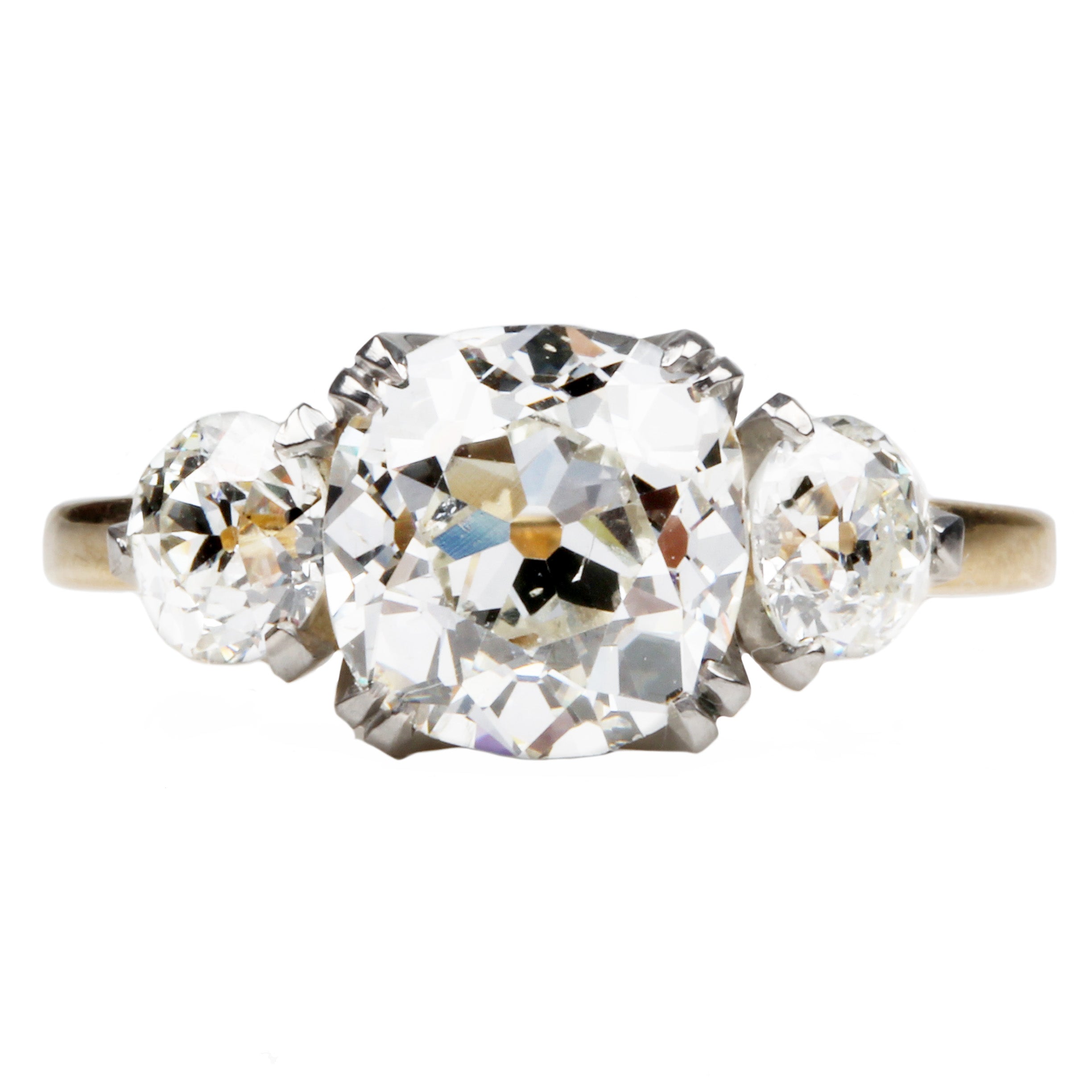 A classic three stone diamond ring with old European cut stones in a platinum-topped gold band.
