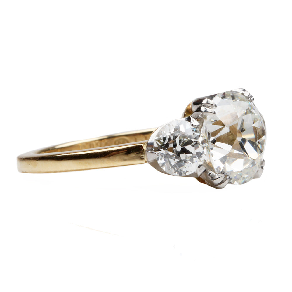 A classic three stone diamond ring with old European cut stones in a platinum-topped gold band.
