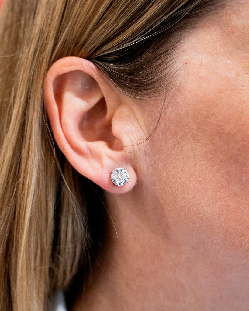 Classic round brilliant cut diamond earring studs. Handmade platinum four-tab prong settings with locking backs. Featuring two GIA certified diamonds, 2.01 carats J color and SI1 clarity and 2.01 I color and SI1 clarity. Over four carats in total weight. Front view of the diamond earrings. Diamonds being worn on the ear lob. 