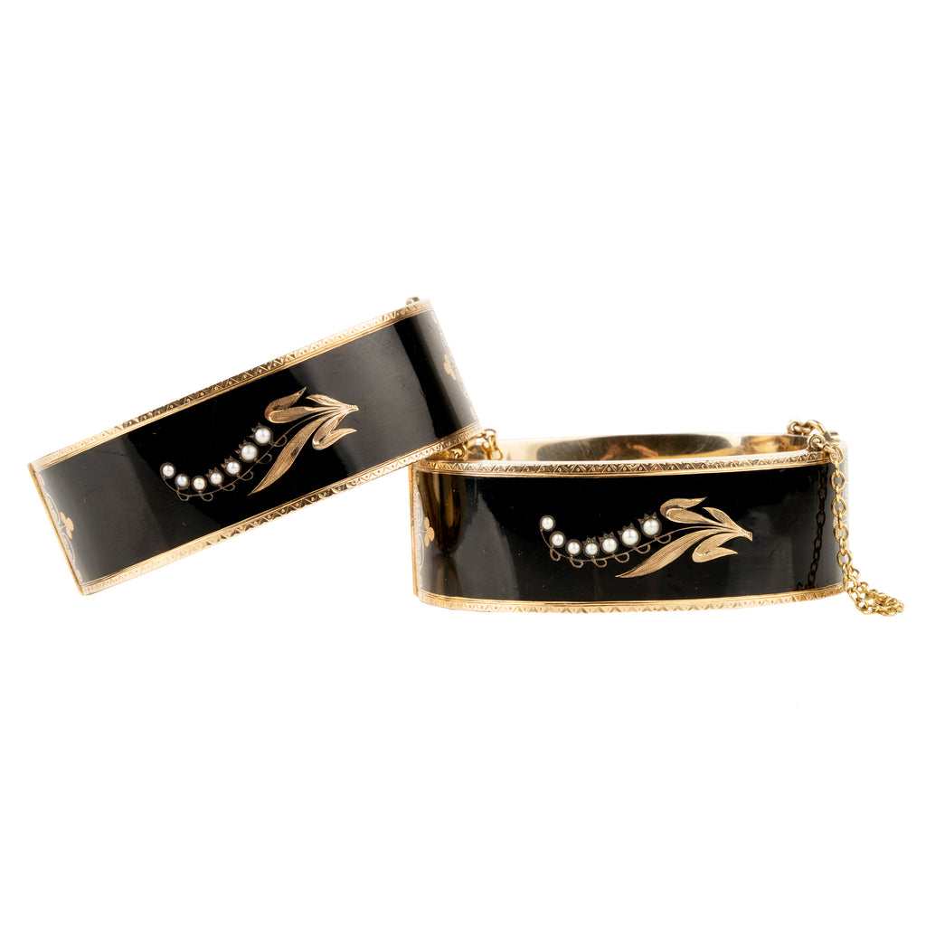 In the 19th century, the Lilly of the Valley flower was a common mourning motif that symbolized a return to happiness. This is a nicely preserved set of 14k gold bracelets with black enamel, pearls and delicate engraving. They are small in size, measuring 5.25 inches in circumference. American, circa 1870. Front view. 