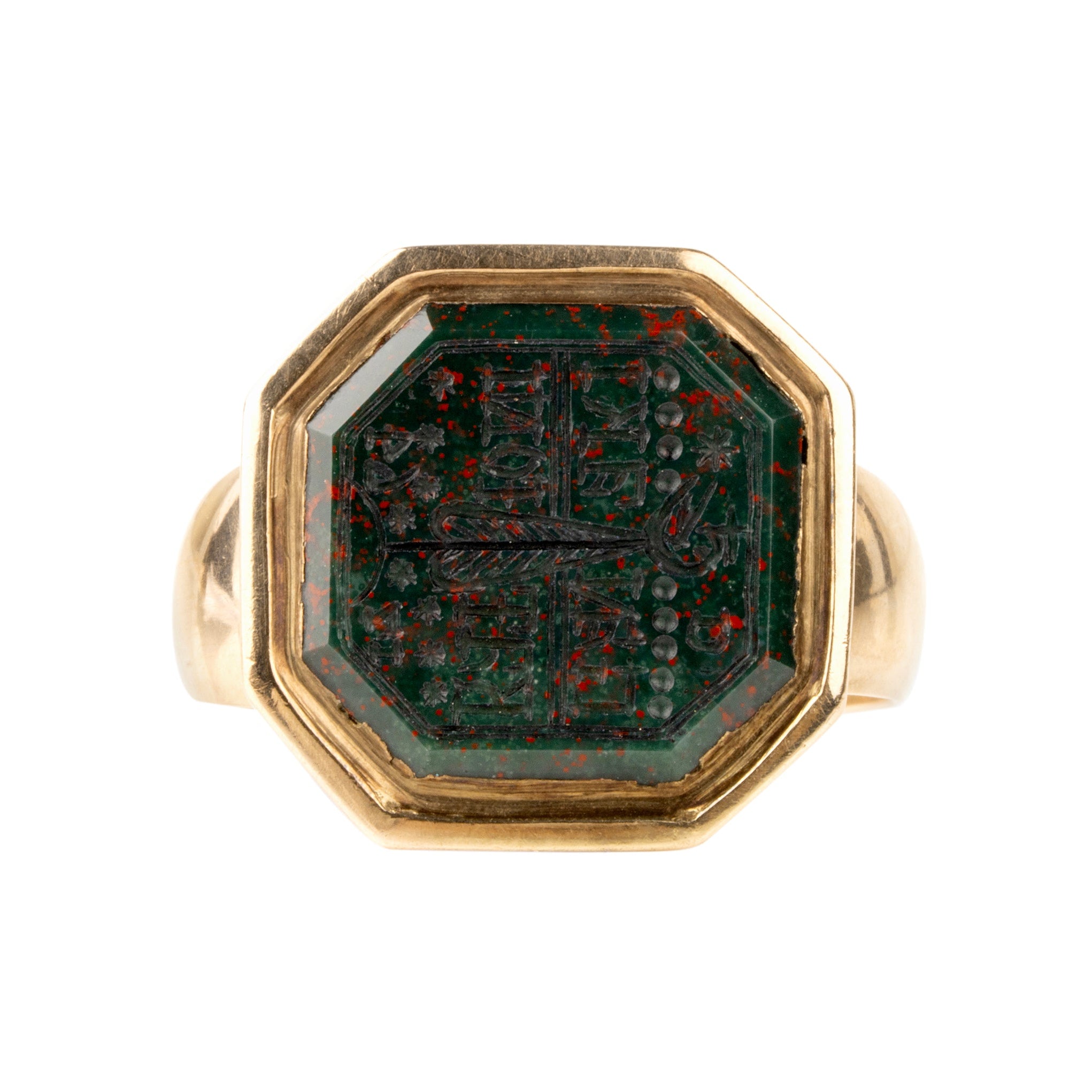 Gold ring with a green stone on a white background