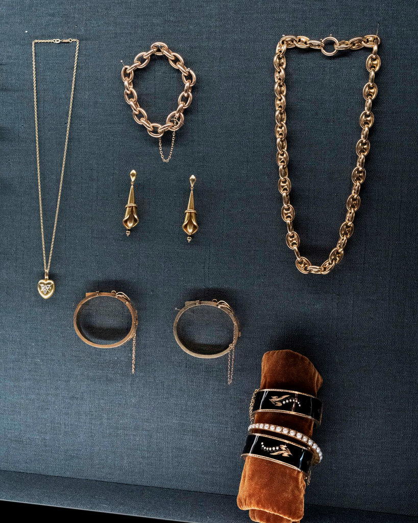 View of a jewelry case with several antique Victorian gold jewelry pieces. 