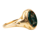 Victorian era deer intaglio signet ring, in 18k gold. Carved bloobstone intaglio depicted a deer holding a brand of leaves set in an engraved gold ring. England. Circa 1870. 