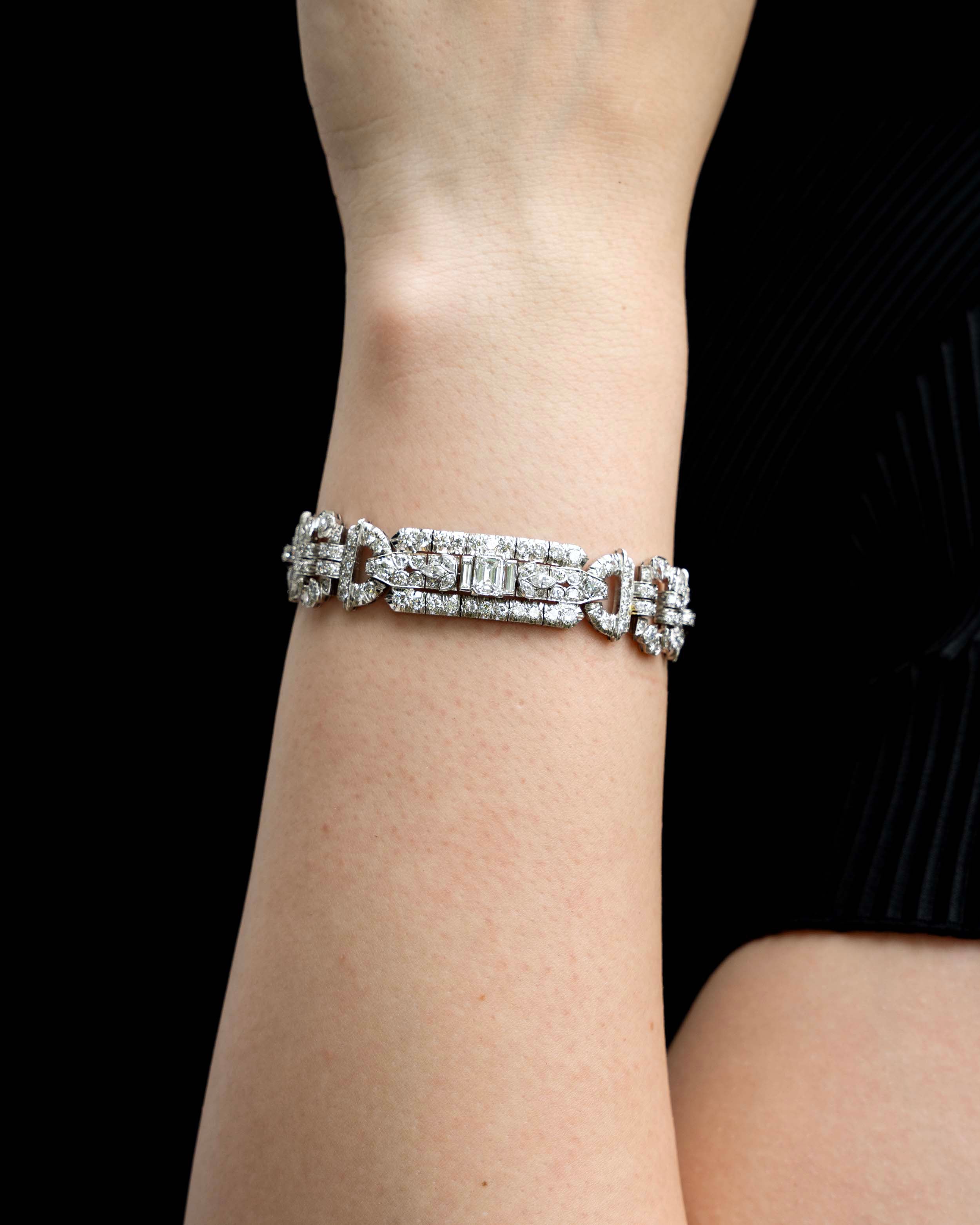 Art Deco platinum and diamond bracelet. Approximately twelve carats of diamonds make up this antique bracelet. There are more than 250 diamonds set in beautifully executed platinum work. The stone shapes include round brilliant cut, single cut, emerald cut, marquise shapes, and baguette shapes. The largest stones are three emerald-cut diamonds weighing approximately .8 carats each. America, circa 1920.