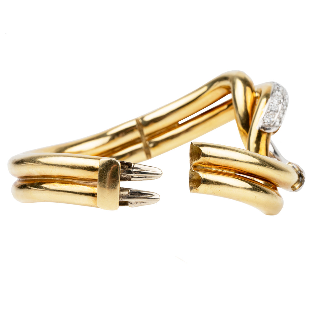 Finely crafted bangle in 18k gold and platinum set with 56 diamonds, approximated total weight 2.5 carats.American in origin. Circa 1970. Side view open. 